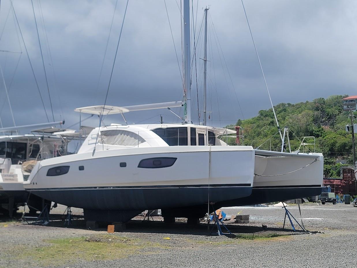 Leopard-44 2015-Kitten Caboodle SC-US-2015 Leopard 44 catamaran on land, cloudy sky, surrounded by greenery.-9762818