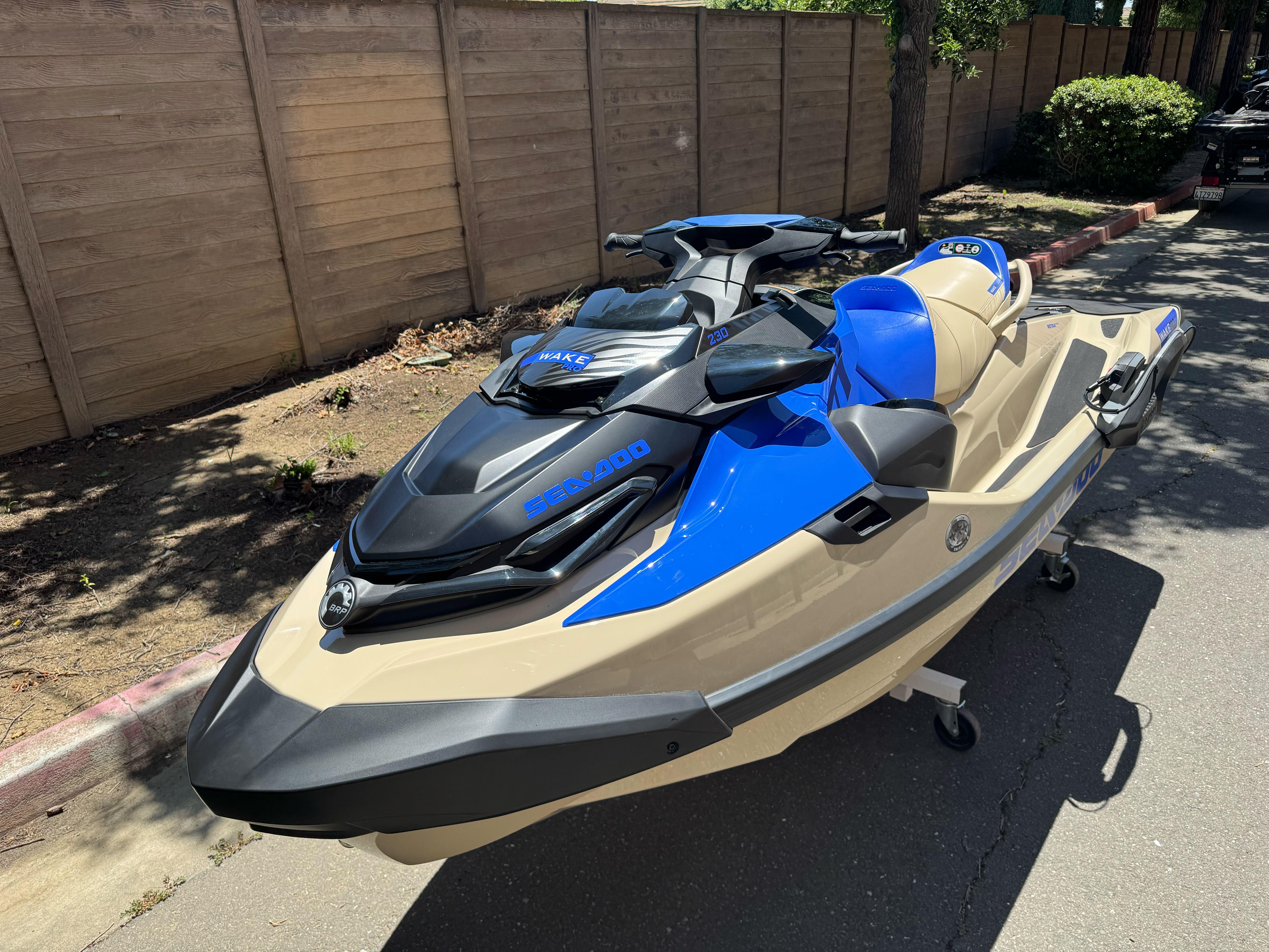2025 Sea-Doo Wake Pro 230 jet ski in blue and beige, parked outdoors.