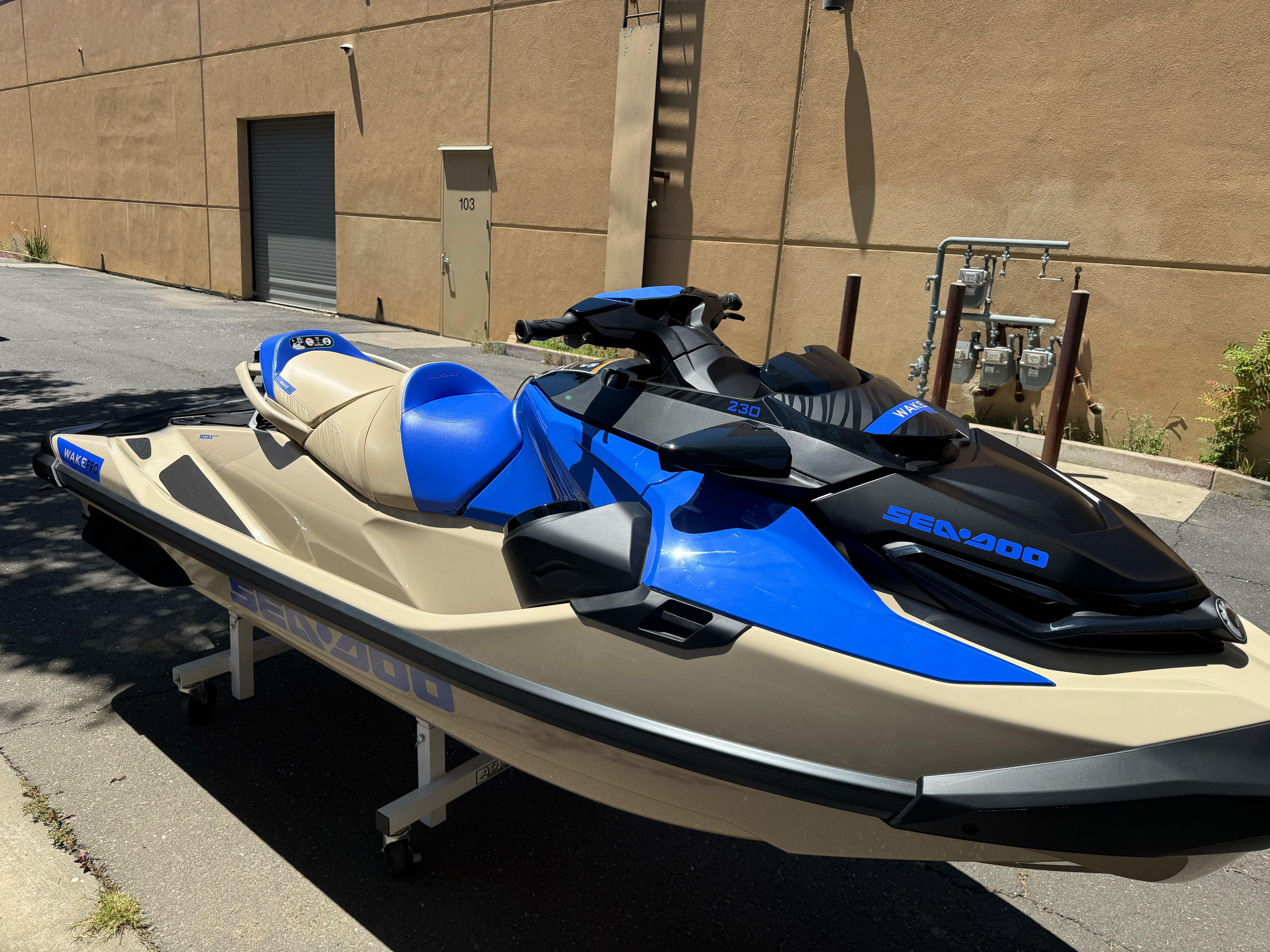 2025 Sea-Doo Wake Pro 230 jet ski in blue and beige, parked outdoors.