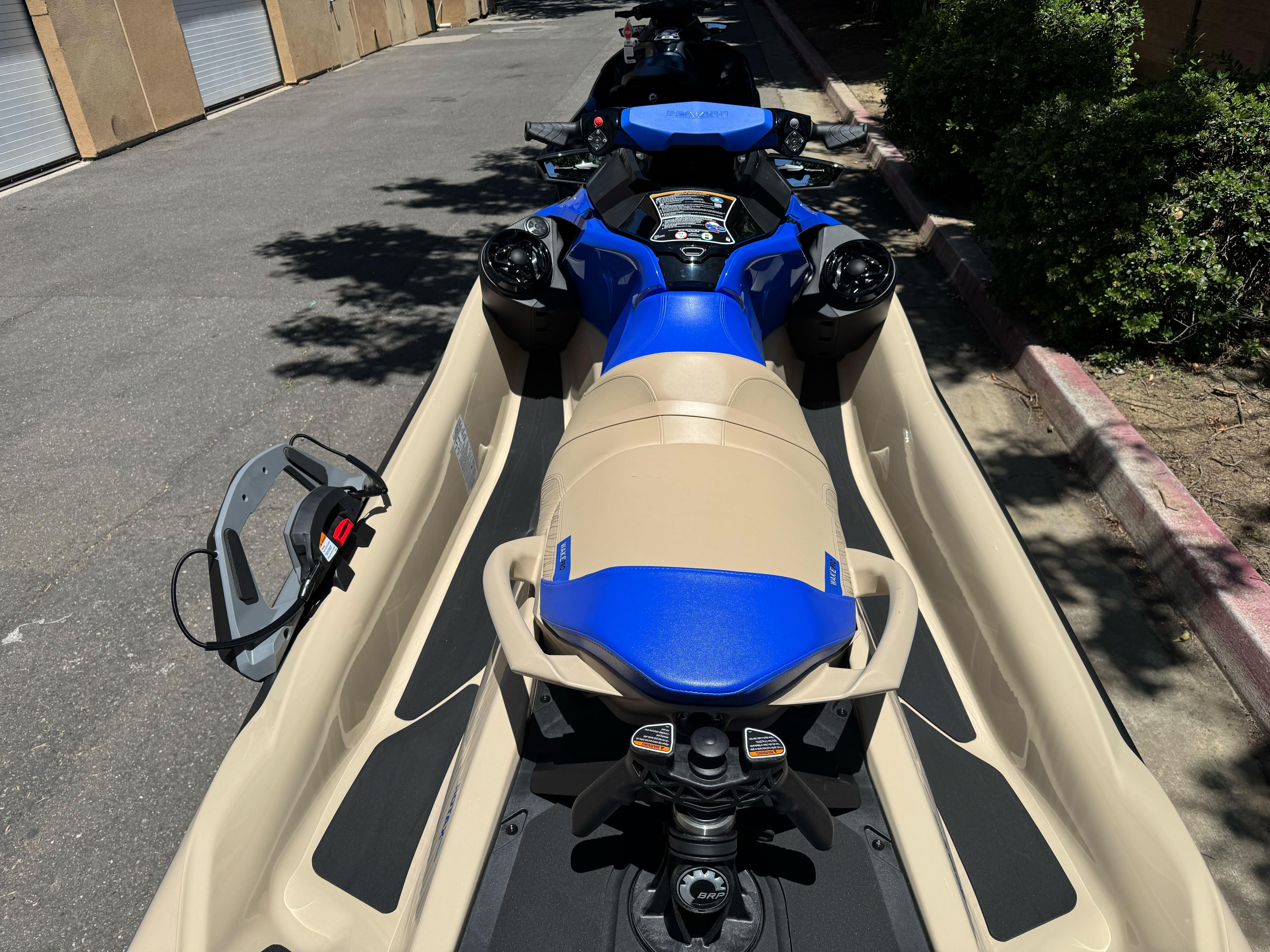 2025 Sea-Doo Wake Pro 230 jet ski in a trailer, parked on a sunny street.