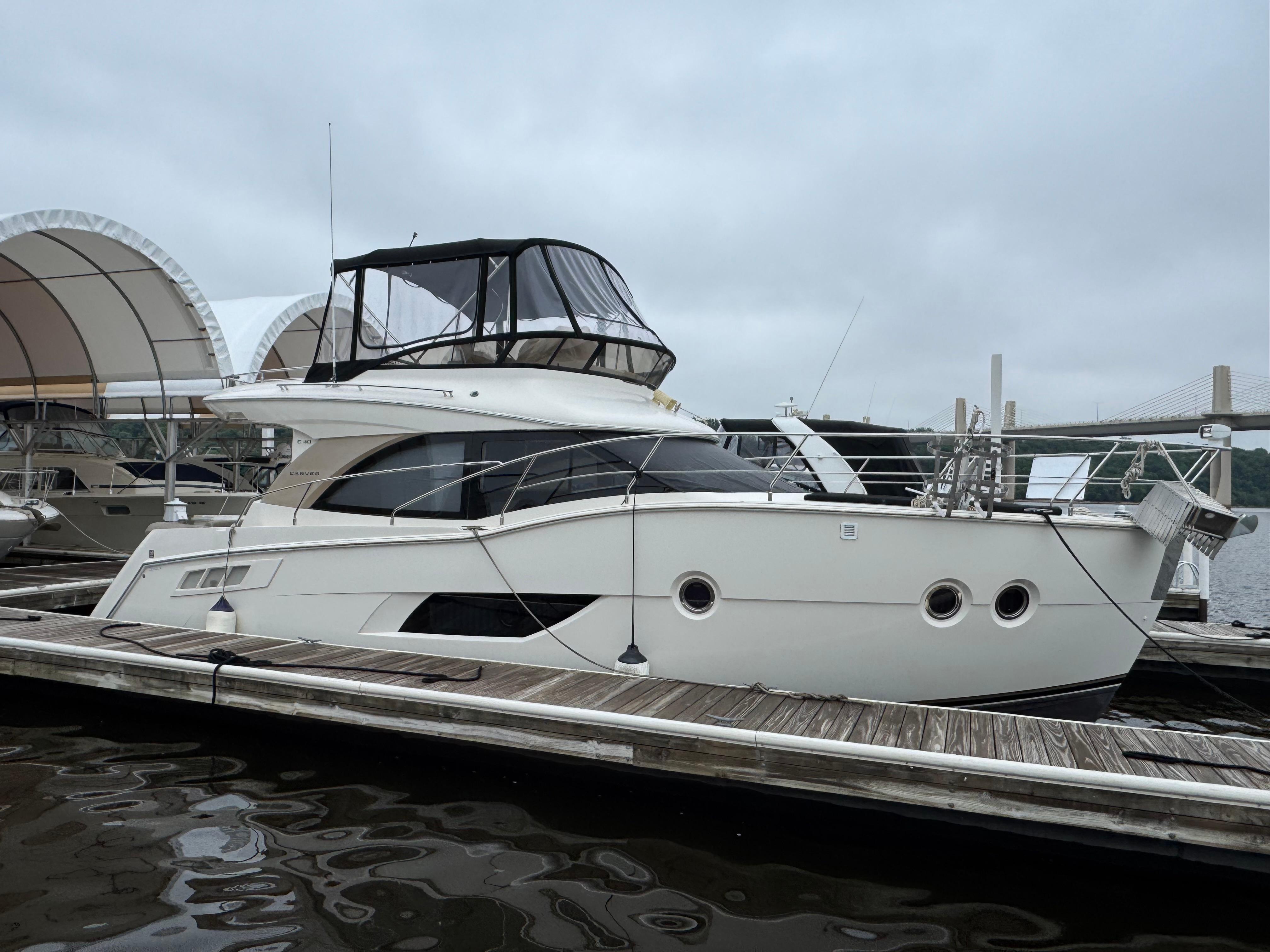 Picture of Casa De Luz Carver 40 ft' C40 Command Bridge 2014 Carver C40 Command Bridge yacht docked at marina under cloudy sky. 