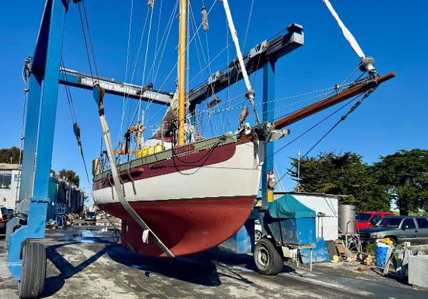 Bristol Channel Cutter 28 sailboat from 1982 being lifted in a boatyard.