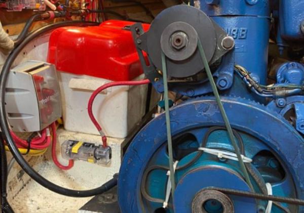 Engine compartment of a 1982 Bristol Channel Cutter 28, featuring a blue engine and red battery.