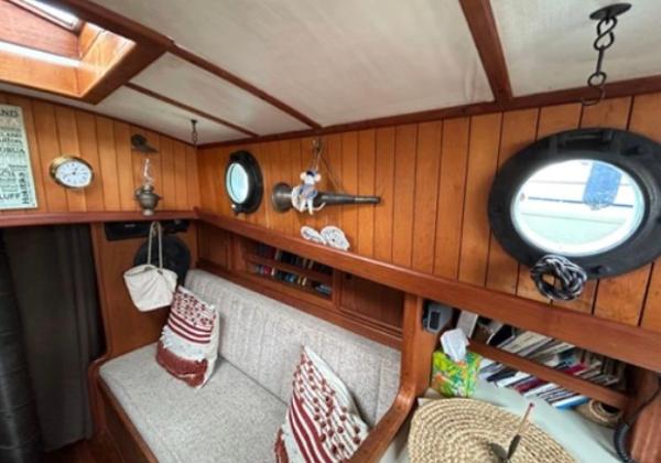 Cozy 1982 Bristol Channel Cutter 28 interior with wood paneling, portholes, and nautical decor.