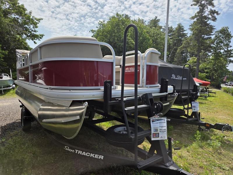 2025 Sun Tracker PB 18 DLX pontoon boat on trailer, displayed outdoors.