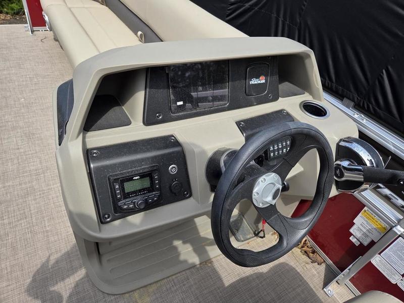 Steering console of 2025 Sun Tracker PB 18 DLX pontoon boat with controls and dashboard.