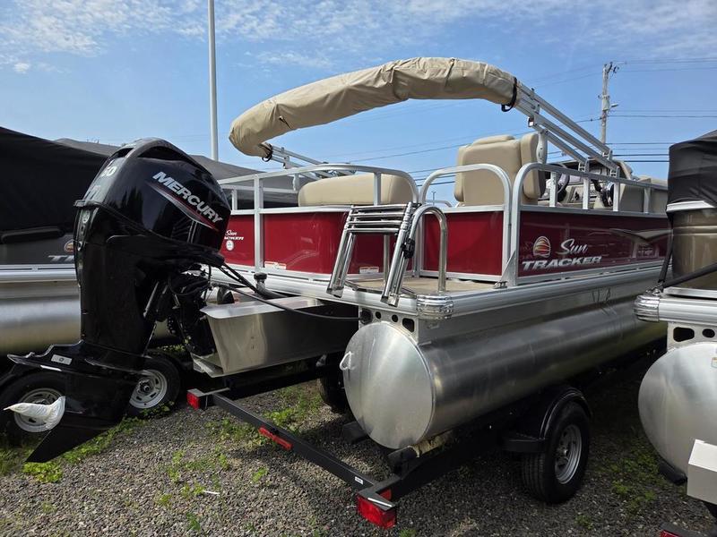 2025 Sun Tracker PB 18 DLX pontoon boat with Mercury outboard motor, parked on trailer.