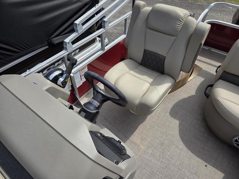 2025 Sun Tracker PB 18 DLX boat interior with beige seating and steering wheel.