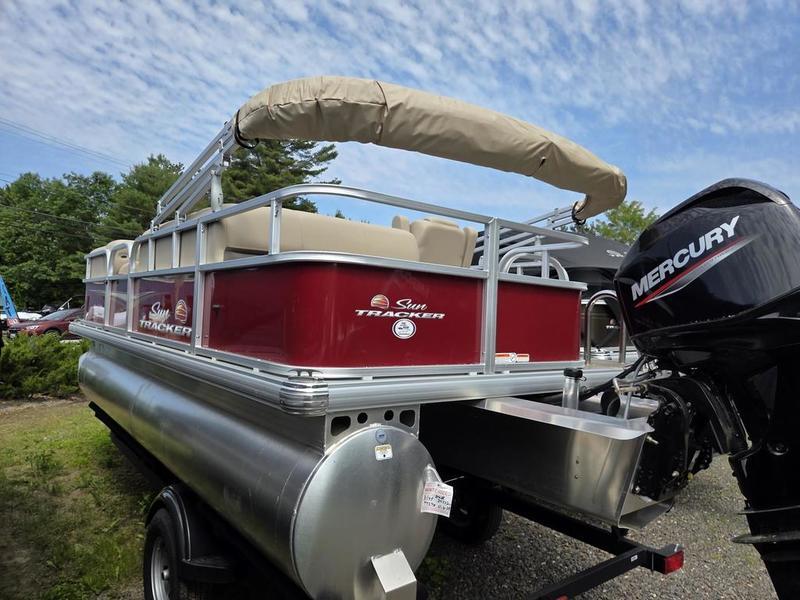 2025 Sun Tracker PB 18 DLX pontoon boat with Mercury engine, parked outdoors.