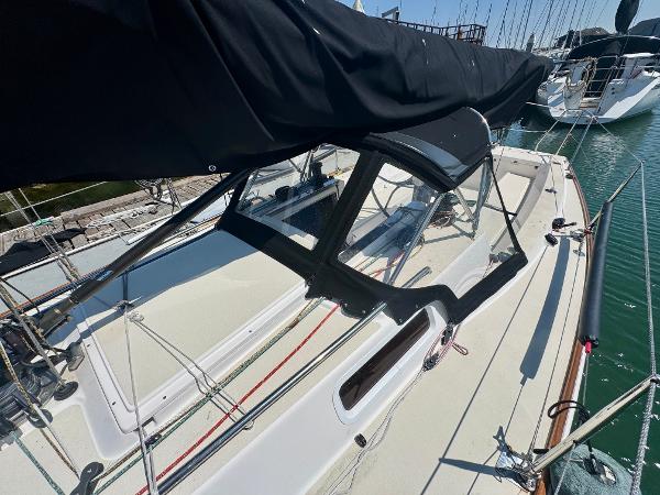 2005 J Boats J/100 sailboat with black canopy docked in marina.