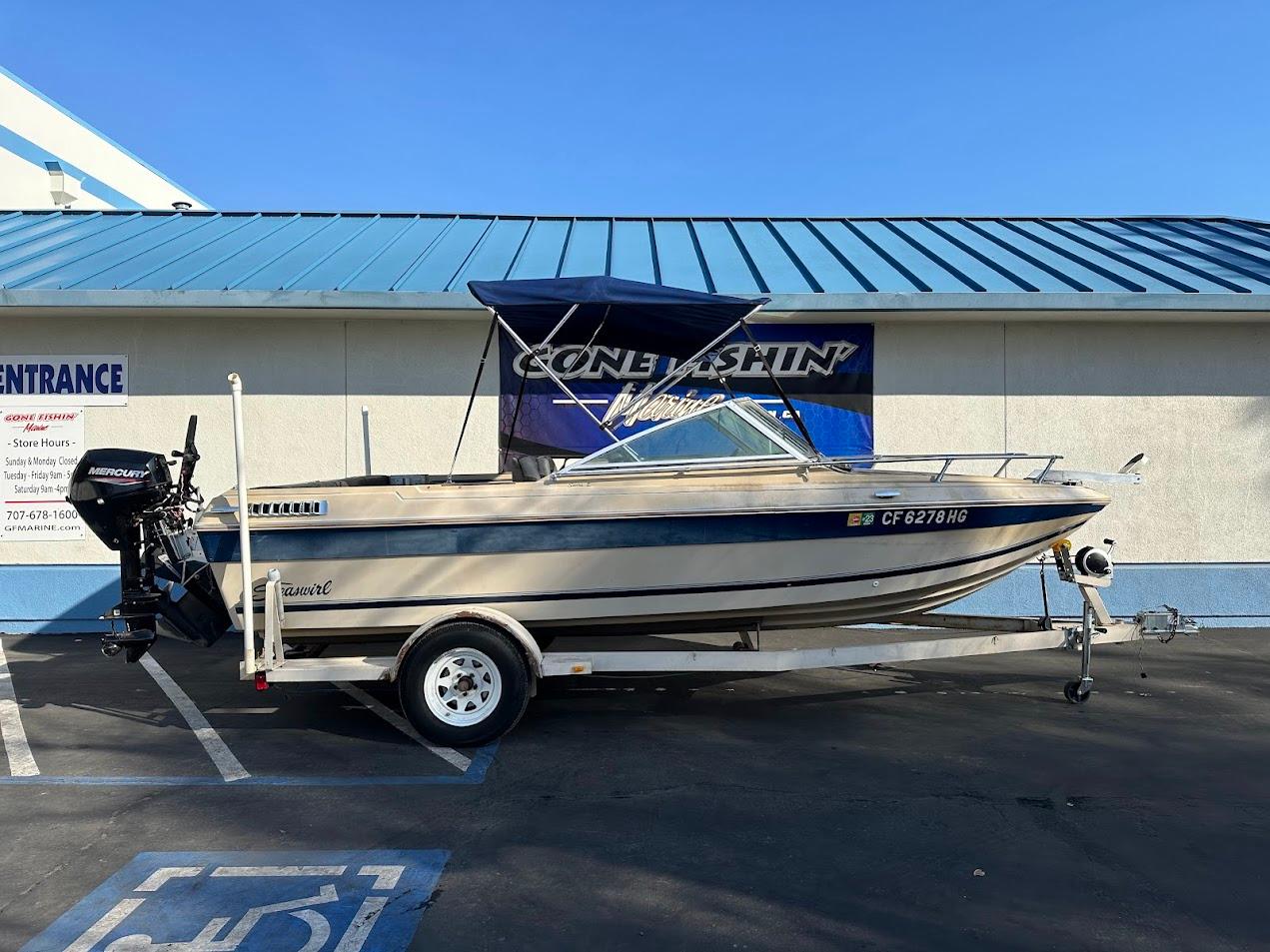 1987 Seaswirl Sierra II boat on trailer, parked outside a building.