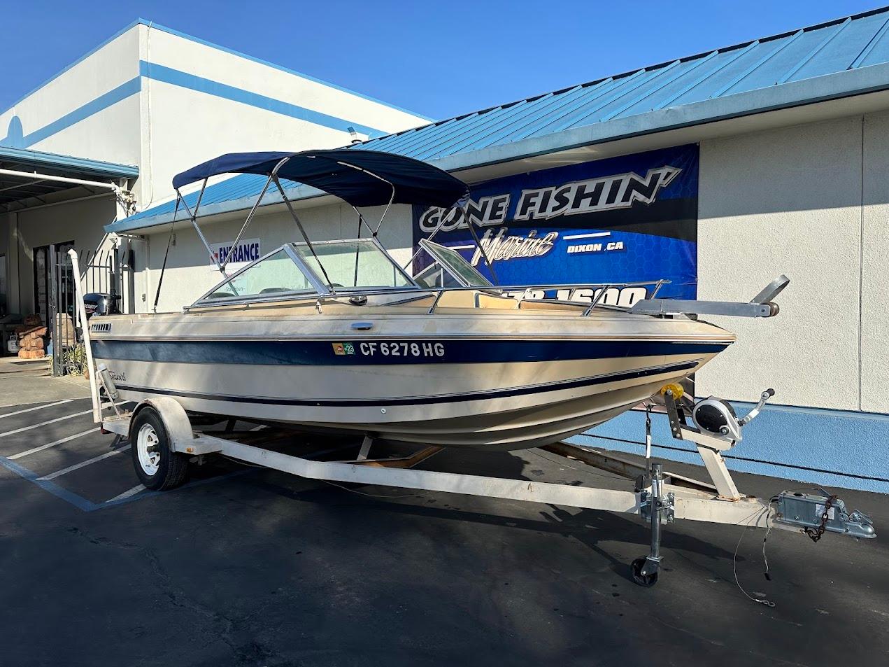 1987 Seaswirl Sierra II boat on trailer, parked outside a building.