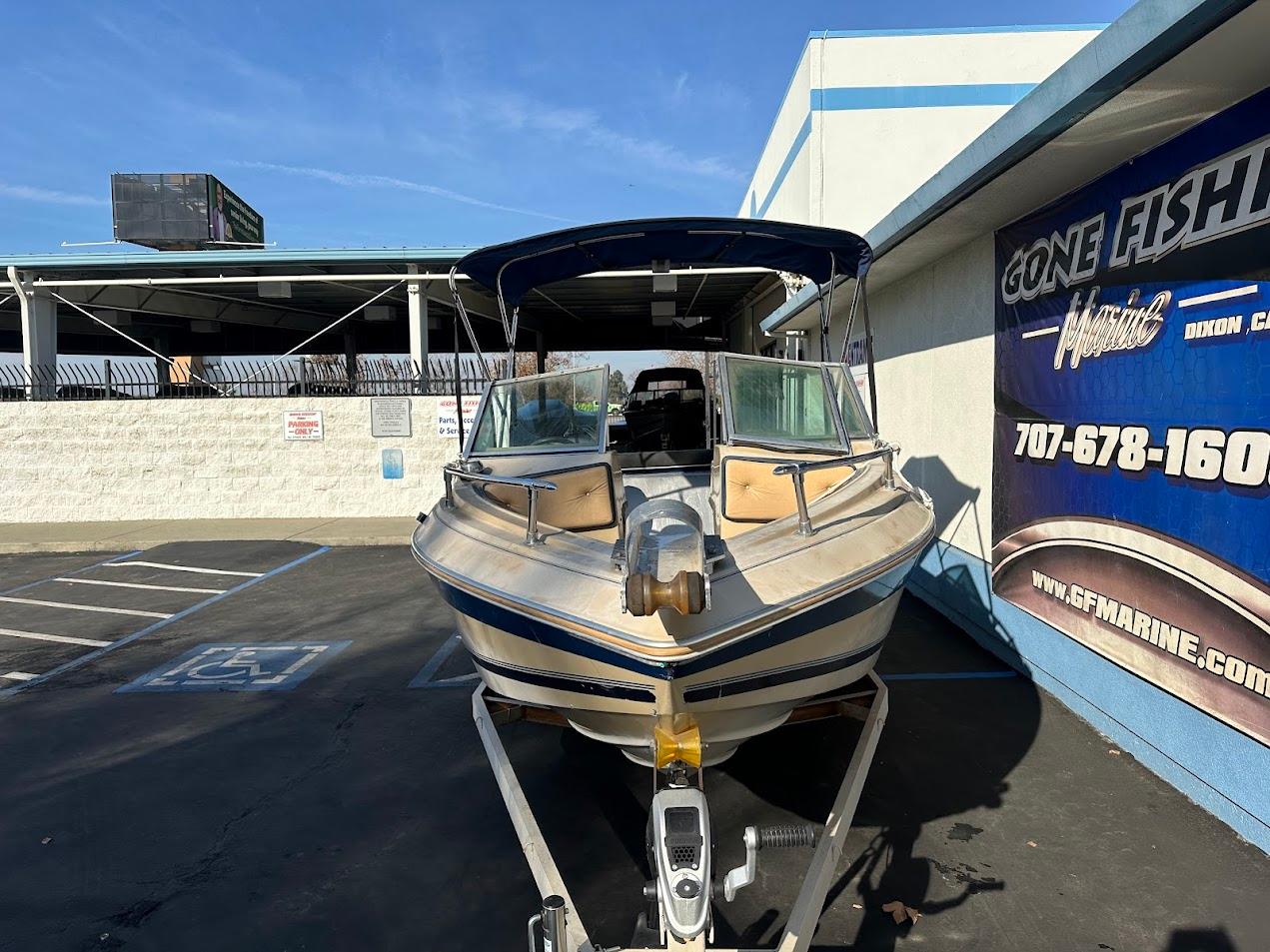 1987 Seaswirl Sierra II boat parked in a marina lot under clear skies.
