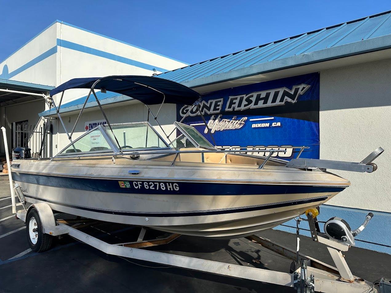 1987 Seaswirl Sierra II boat on trailer, parked outside a building with 