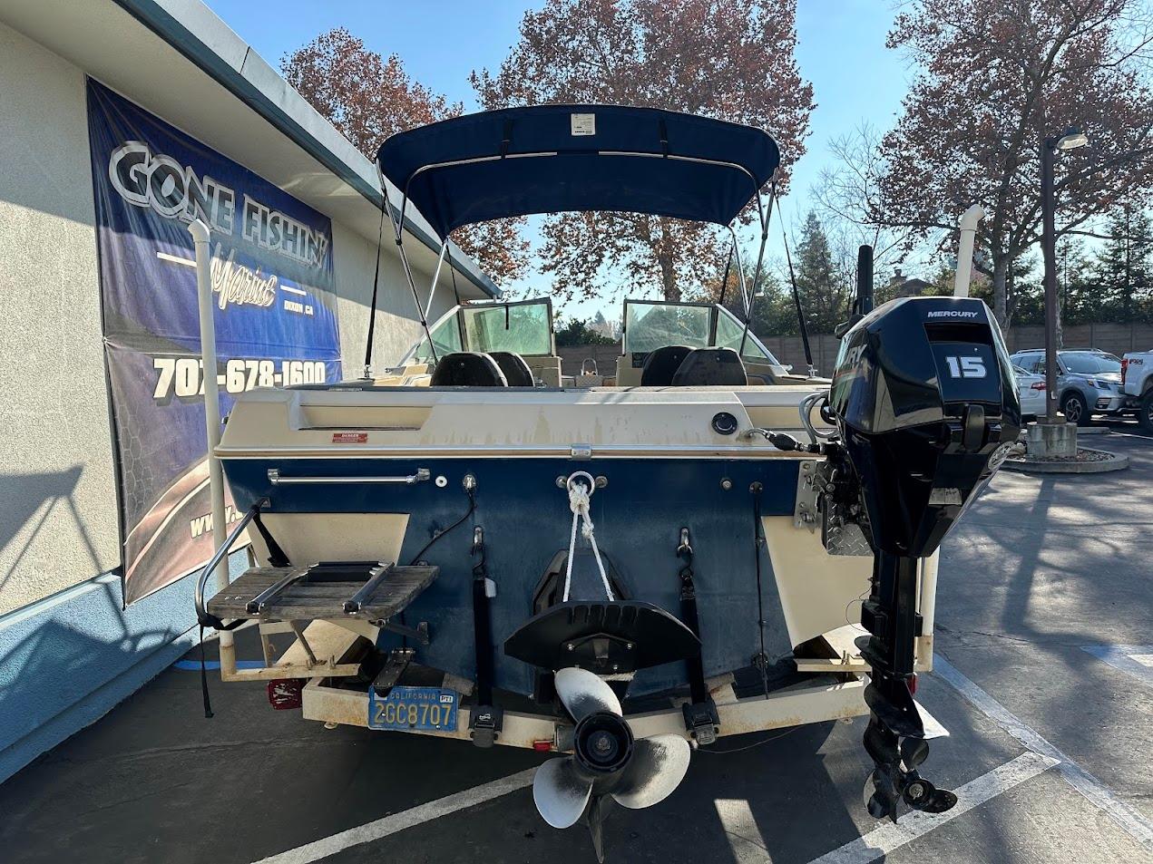 1987 Seaswirl Sierra II boat with outboard motor in parking lot.