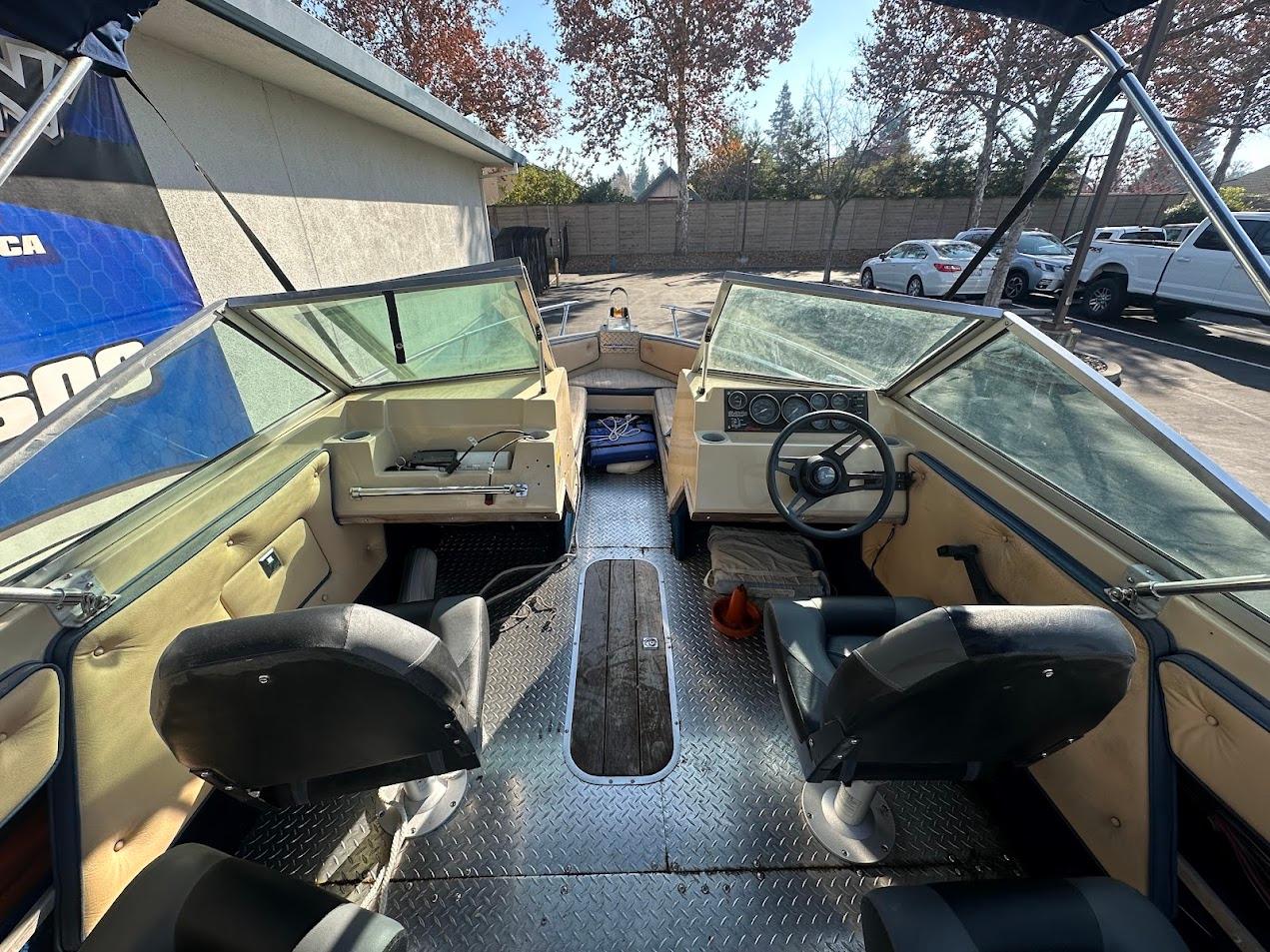 Interior of 1987 Seaswirl Sierra II boat with seating and steering wheel.