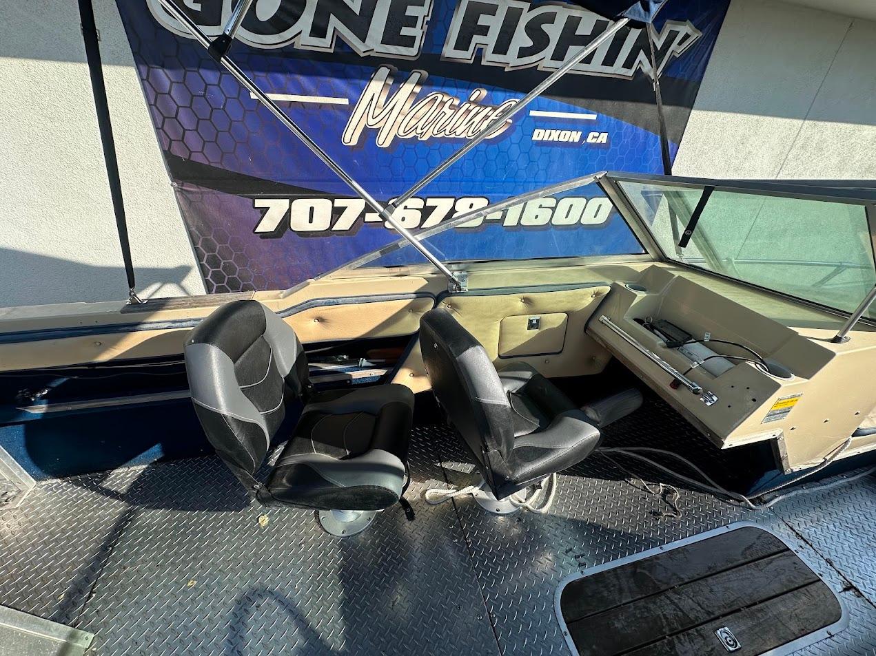 1987 Seaswirl Sierra II boat interior with two black seats and control panel.
