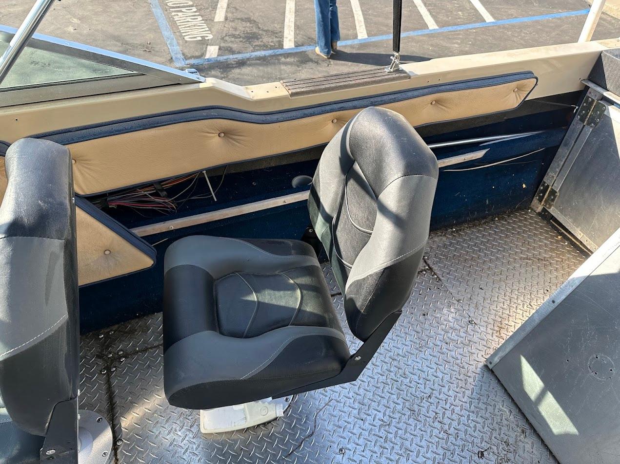 1987 Seaswirl Sierra II boat interior with black seat and metal flooring.