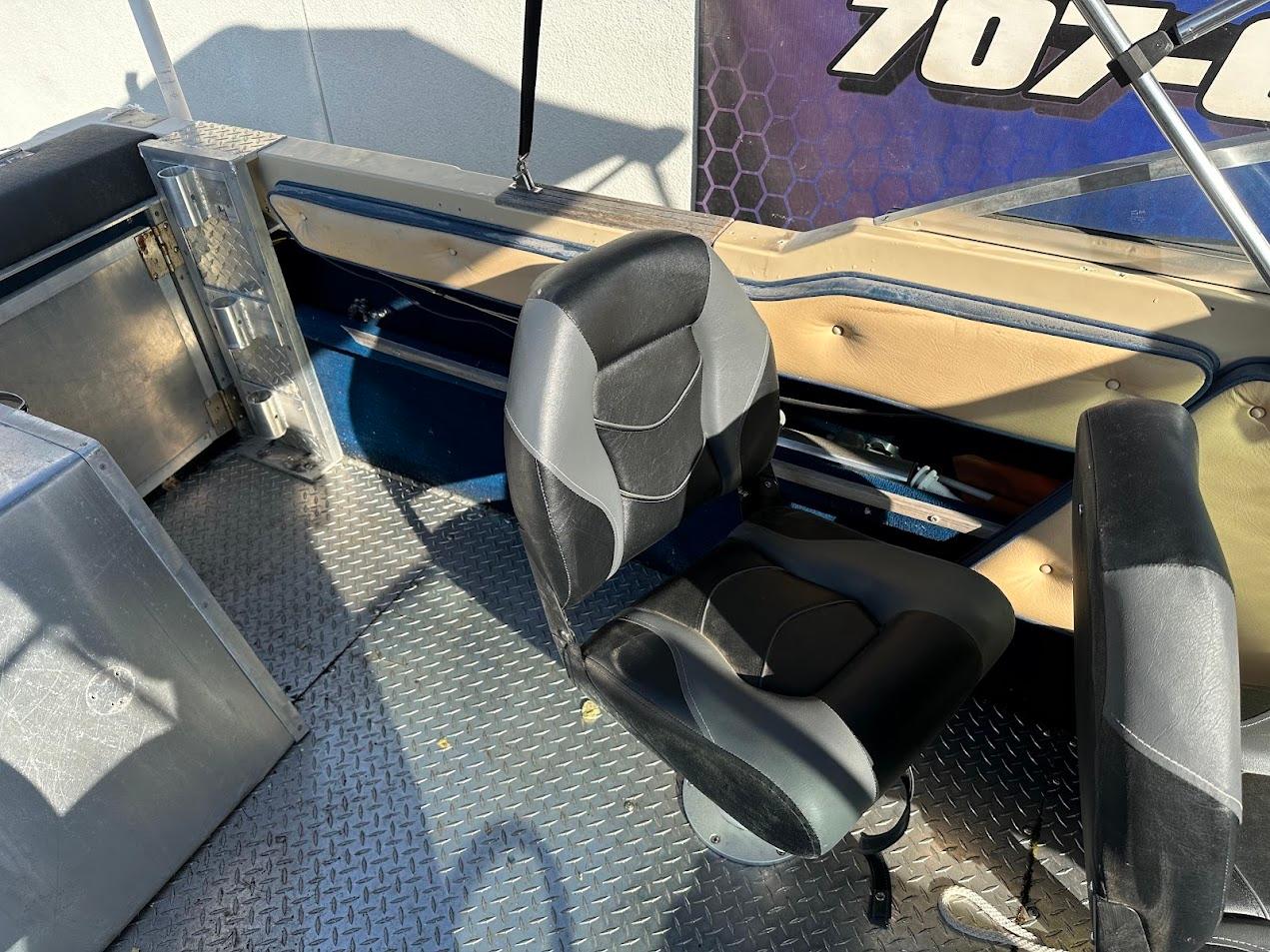 1987 Seaswirl Sierra II boat interior with black seat and metal flooring.