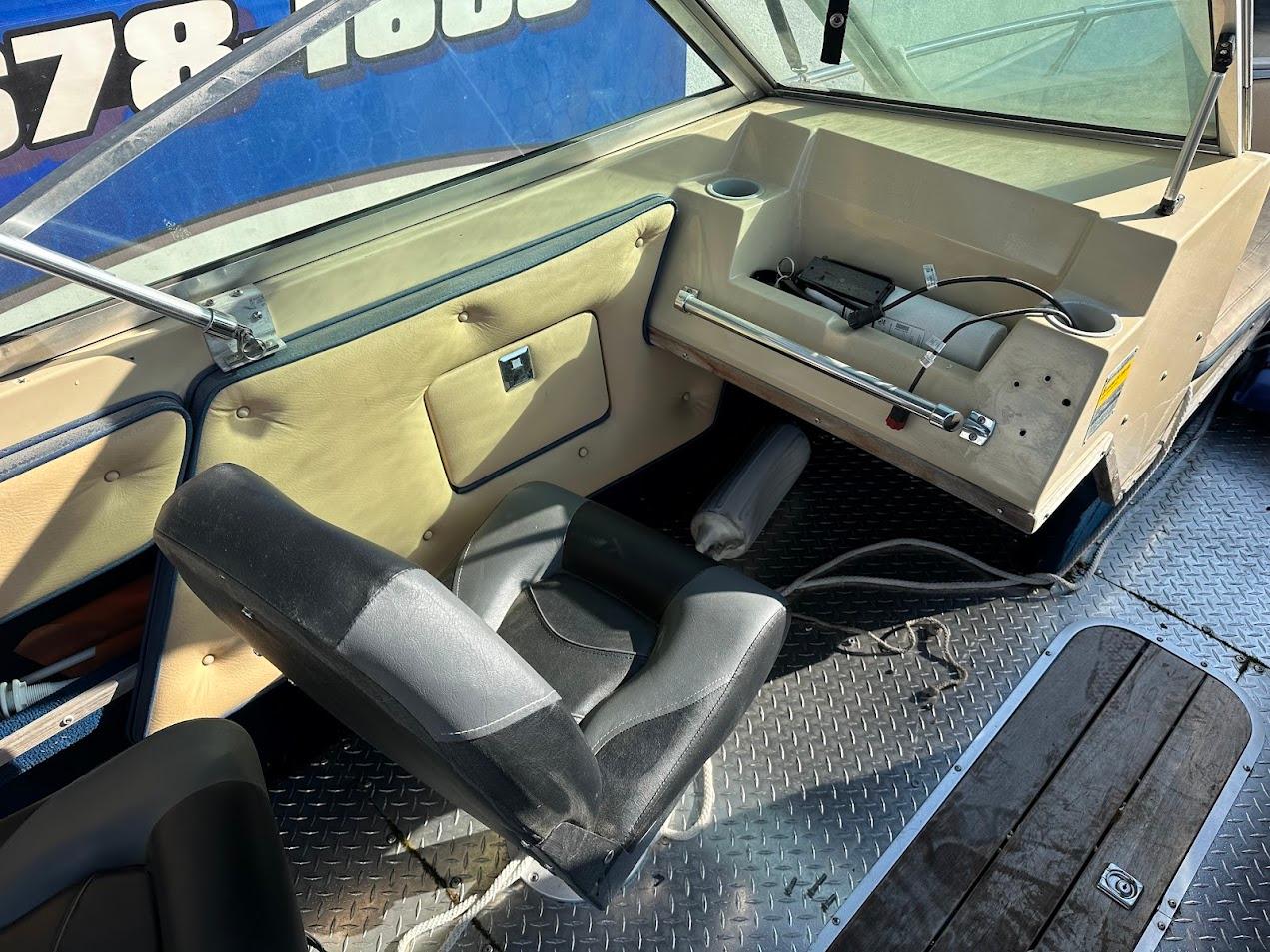 1987 Seaswirl Sierra II boat interior with seating and dashboard.