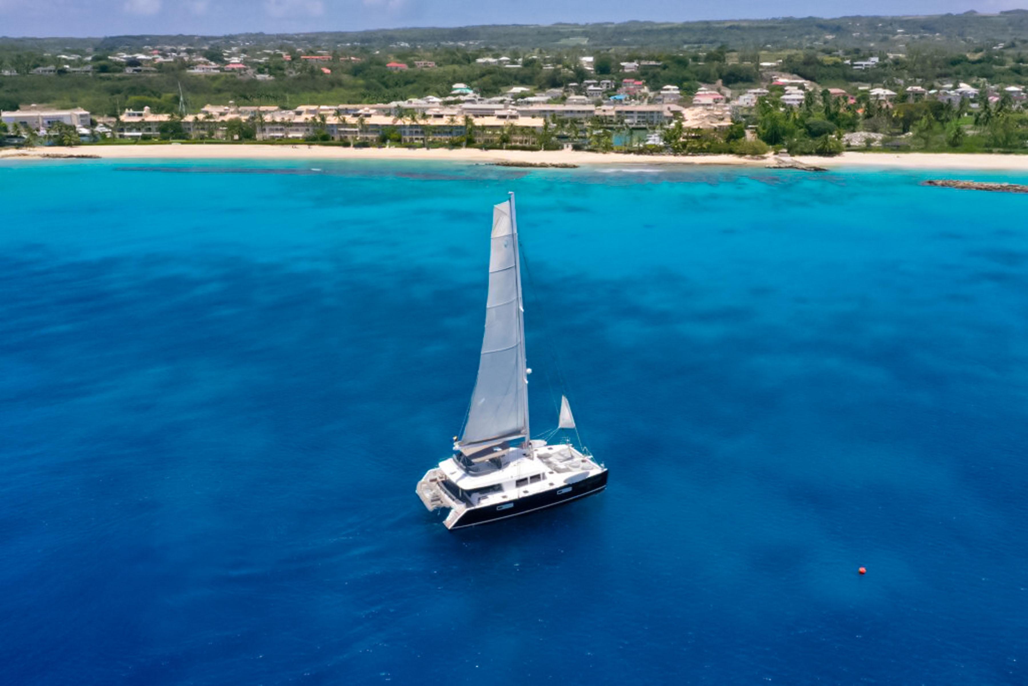 Lagoon-560 S2 2015-Cool Runnings IV SC-US-Sailing Lagoon 560 S2 catamaran on vibrant blue ocean near tropical coastline, 2015 model.-9782915 | Thumbnail