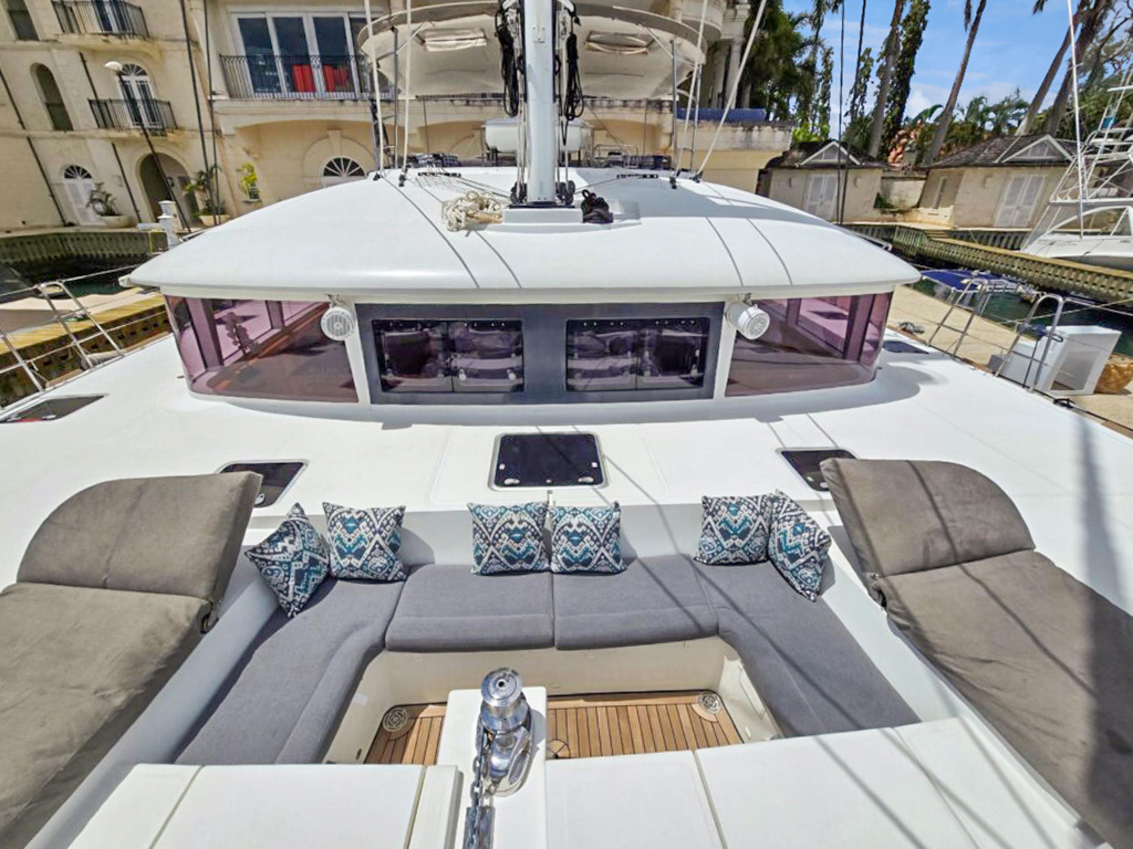 Lagoon-560 S2 2015-Cool Runnings IV SC-US-Lagoon 560 S2 yacht deck with cushioned seating, 2015 model, docked near a building.-9782915 | Thumbnail