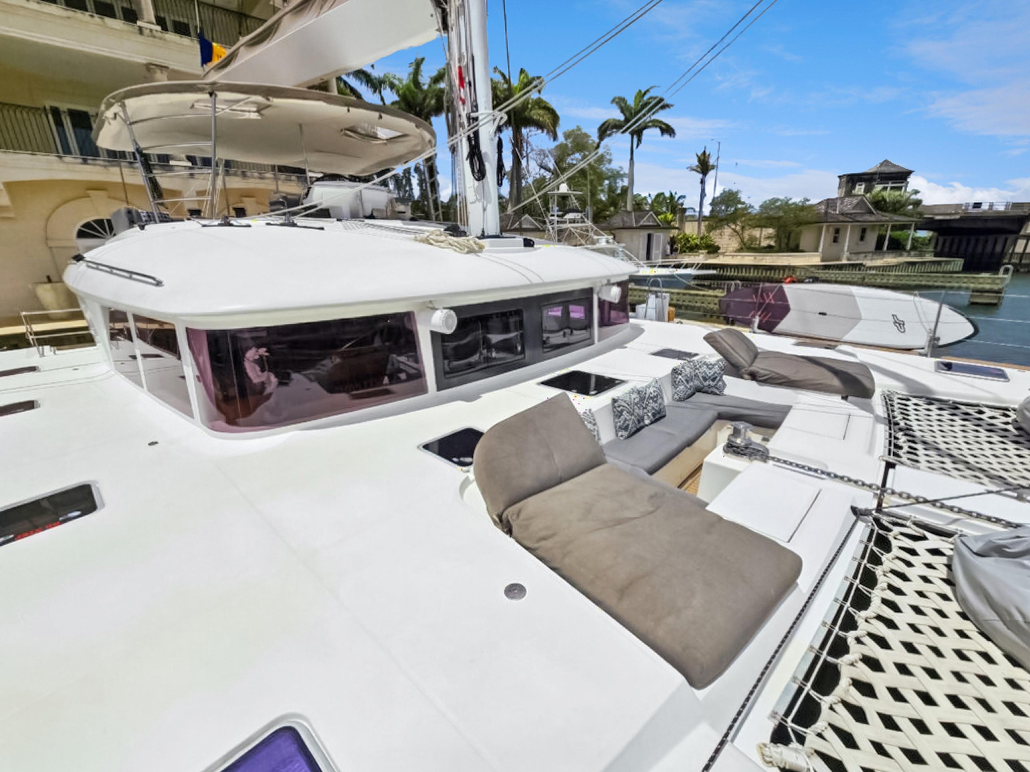 Lagoon-560 S2 2015-Cool Runnings IV SC-US-2015 Lagoon 560 S2 yacht with spacious deck and seating, docked in a tropical marina.-9782915 | Thumbnail