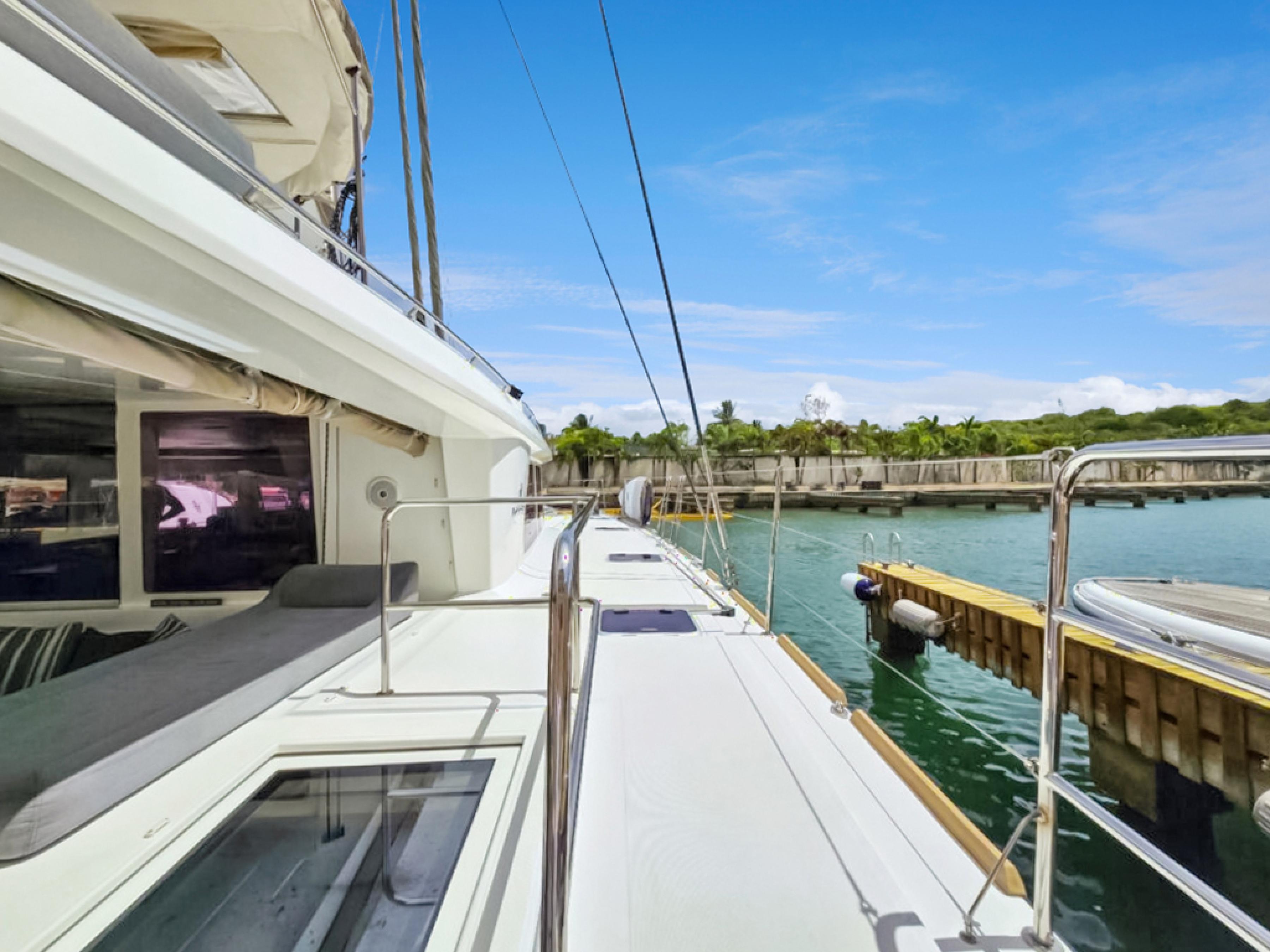 Lagoon-560 S2 2015-Cool Runnings IV SC-US-2015 Lagoon 560 S2 yacht docked in a serene marina under a clear blue sky.-9782915 | Thumbnail