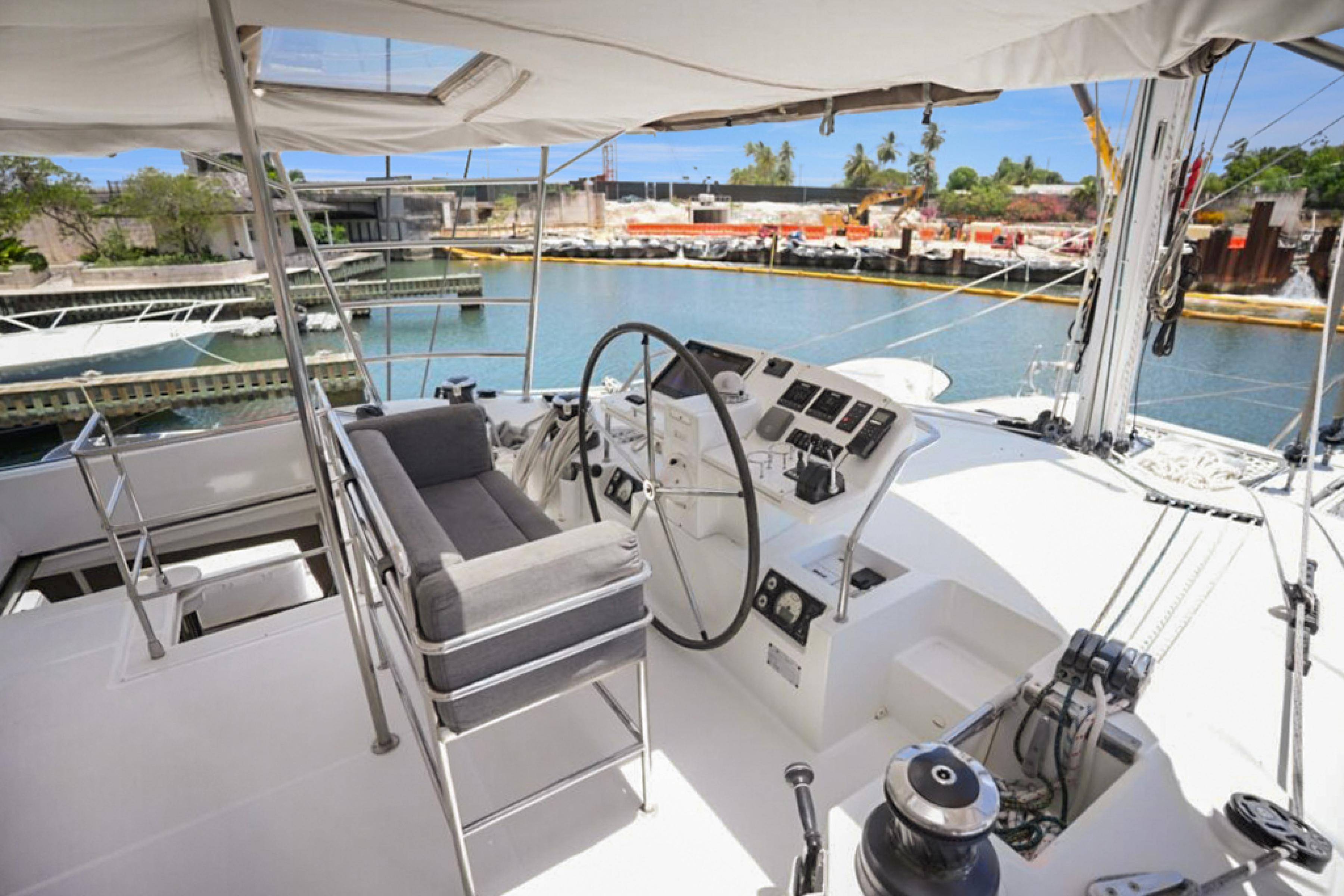Lagoon-560 S2 2015-Cool Runnings IV SC-US-2015 Lagoon 560 S2 yacht cockpit with steering wheel, docked in a marina.-9782915 | Thumbnail