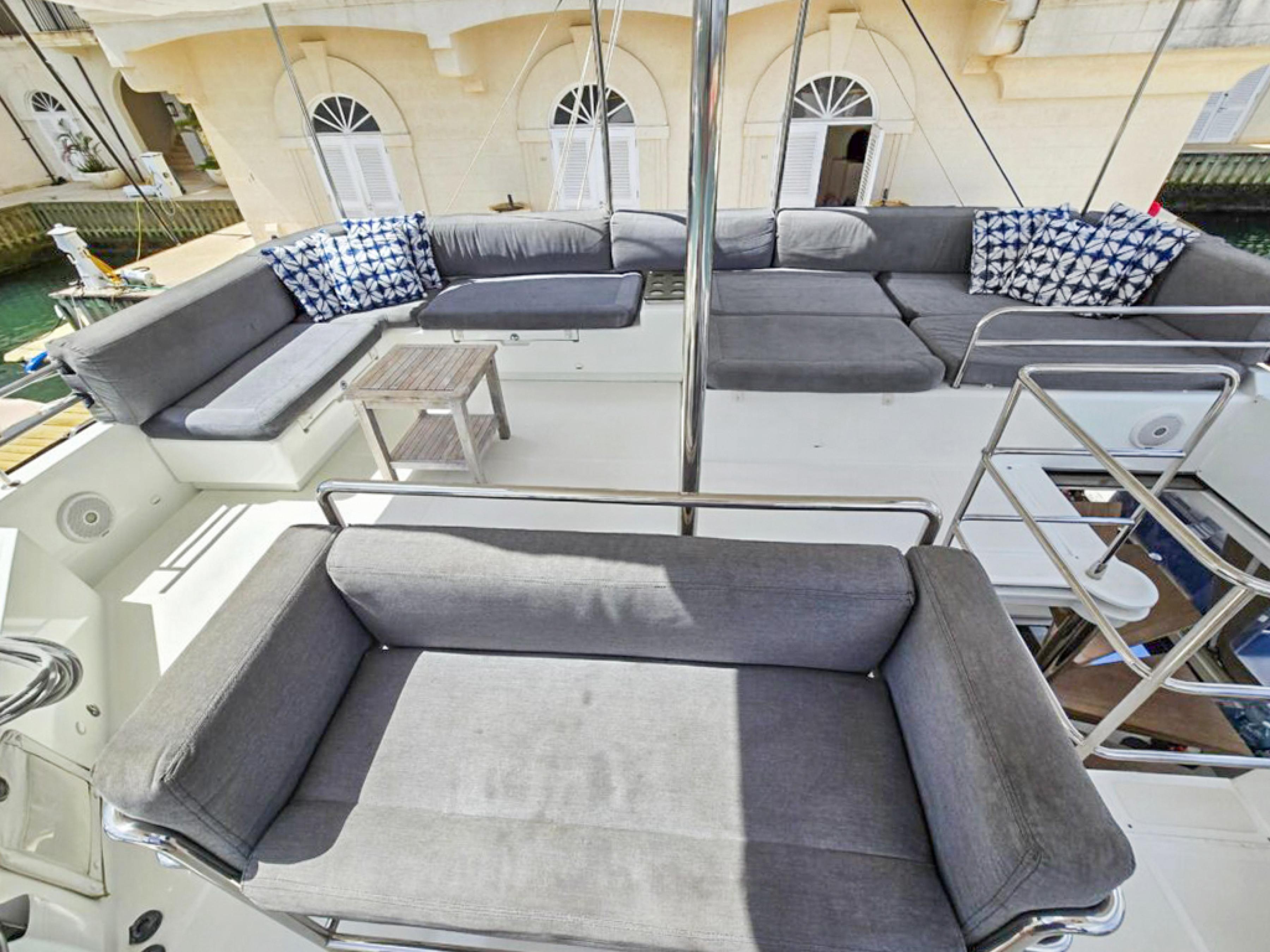 Lagoon-560 S2 2015-Cool Runnings IV SC-US-Spacious deck seating on 2015 Lagoon 560 S2 yacht with gray cushions and patterned pillows.-9782915 | Thumbnail