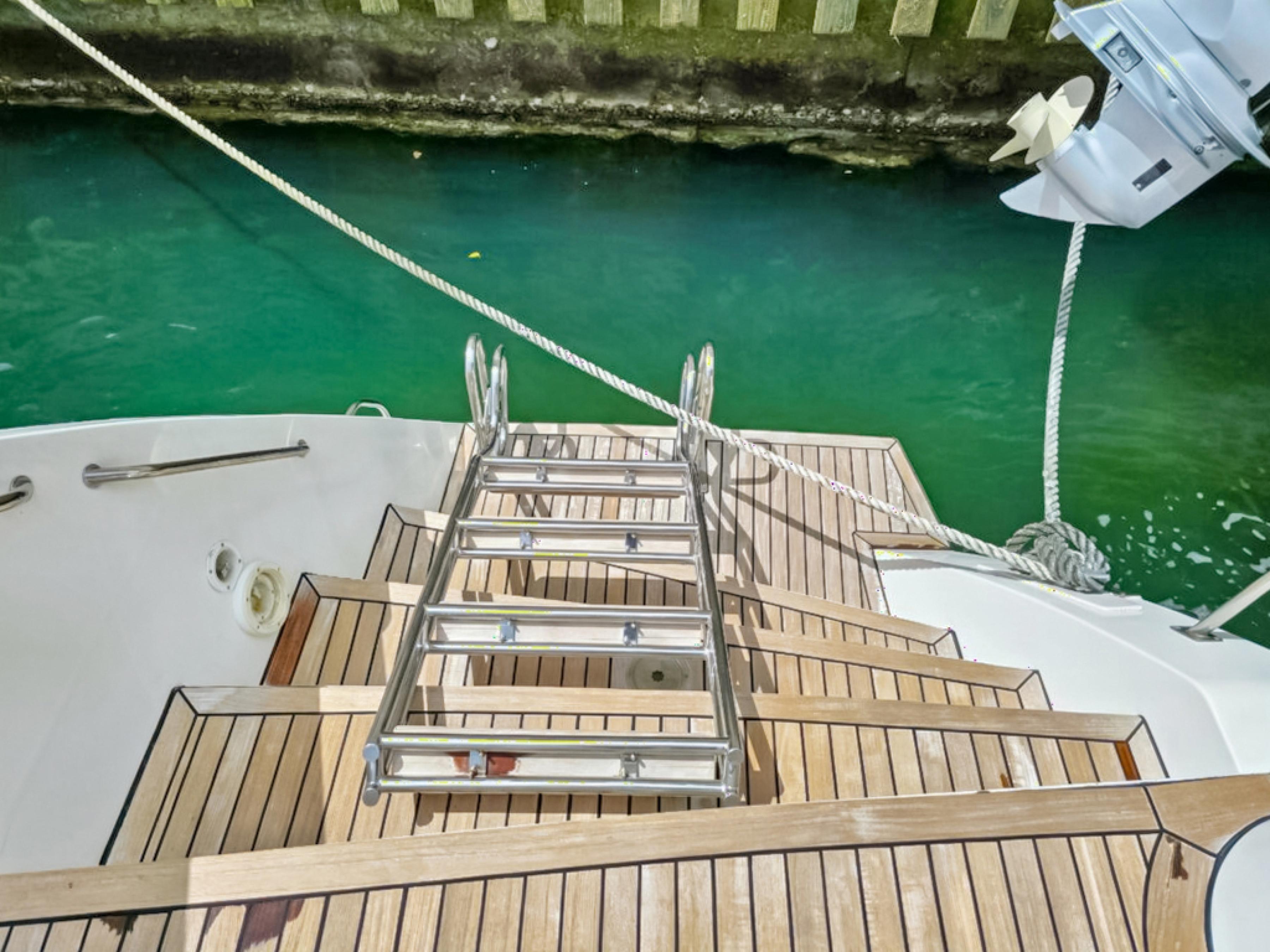 Lagoon-560 S2 2015-Cool Runnings IV SC-US-Wooden deck and ladder of 2015 Lagoon 560 S2 yacht by turquoise water.-9782915 | Thumbnail