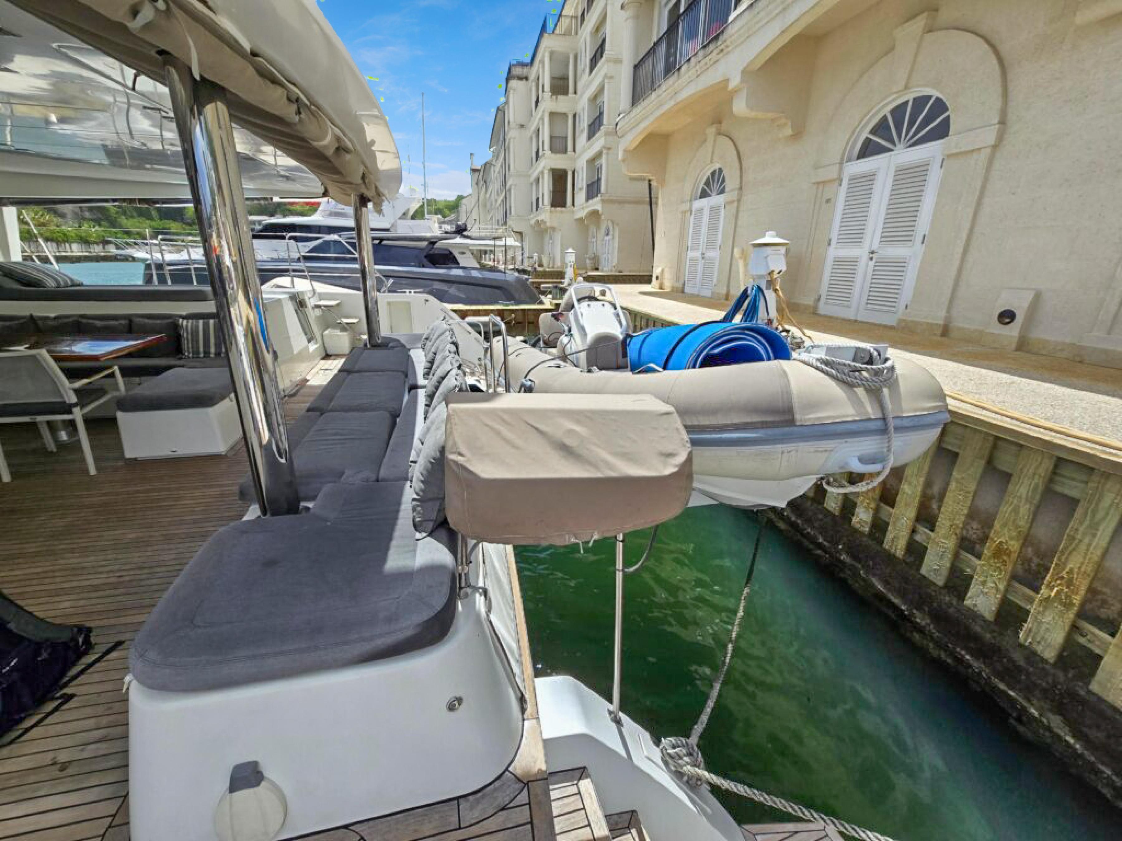 Lagoon-560 S2 2015-Cool Runnings IV SC-US-2015 Lagoon 560 S2 yacht docked, featuring spacious deck and tender boat.-9782915 | Thumbnail