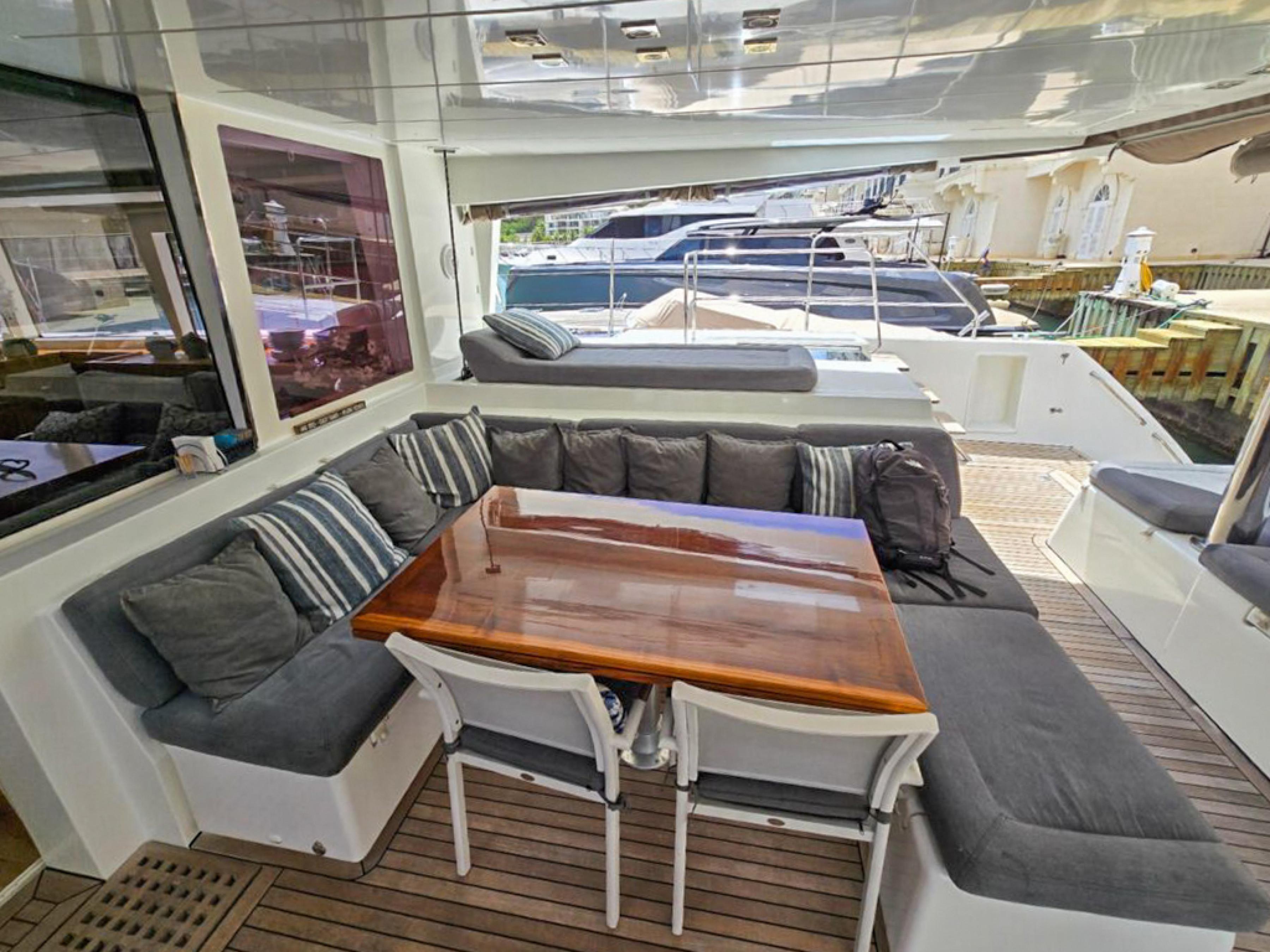 Lagoon-560 S2 2015-Cool Runnings IV SC-US-Spacious outdoor seating on 2015 Lagoon 560 S2 yacht with wooden table and cushions.-9782915 | Thumbnail