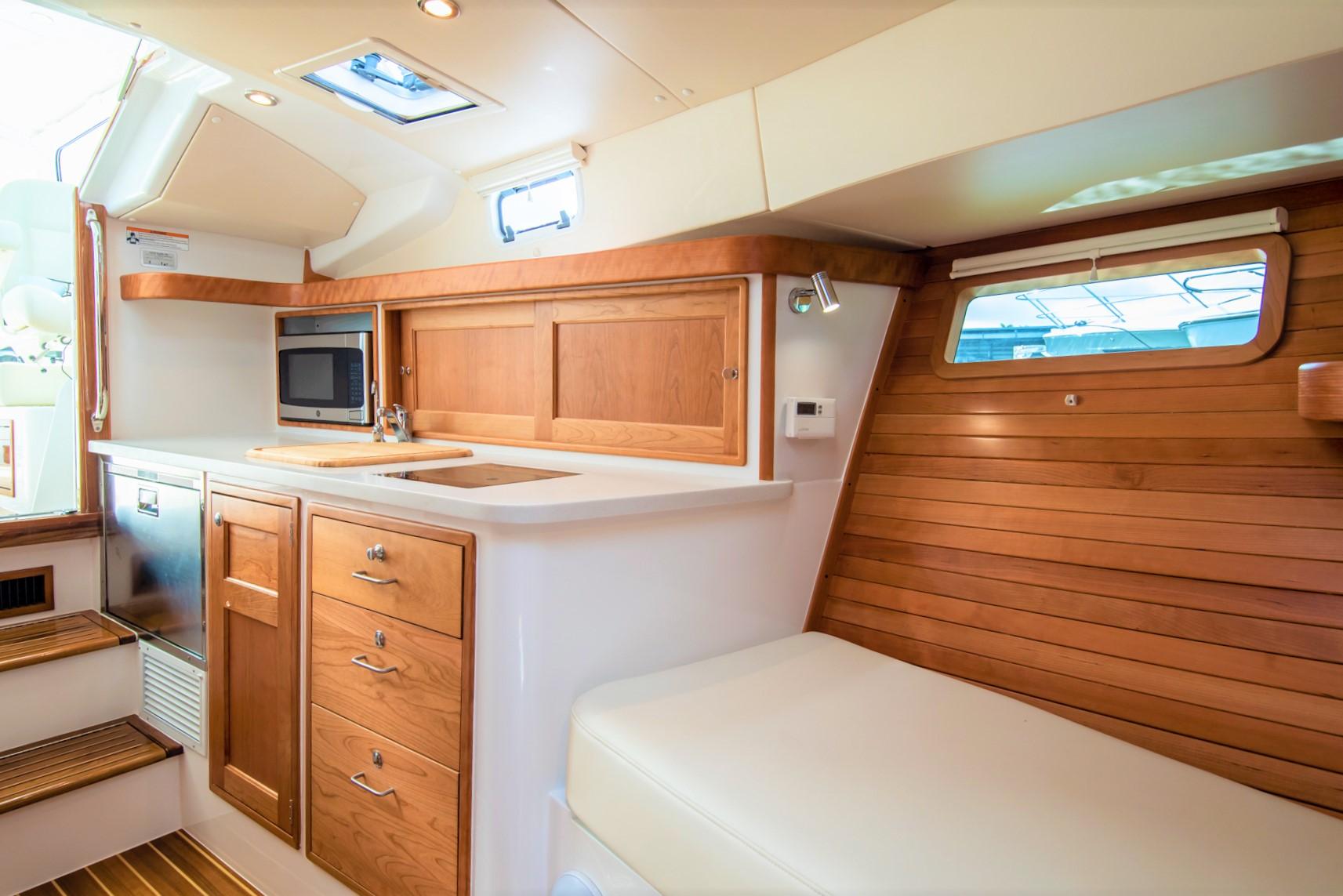 Interior of 2023 MJM 35 boat with wooden cabinetry and modern amenities.