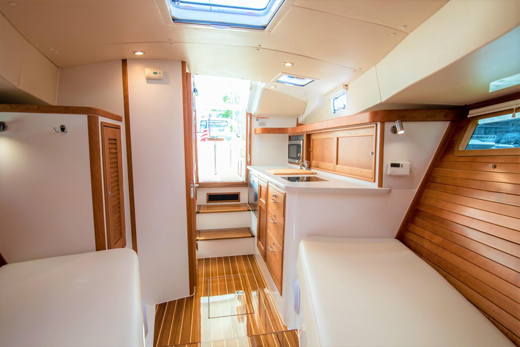 Luxurious interior of 2023 MJM 35 yacht with modern kitchen and wooden finishes.