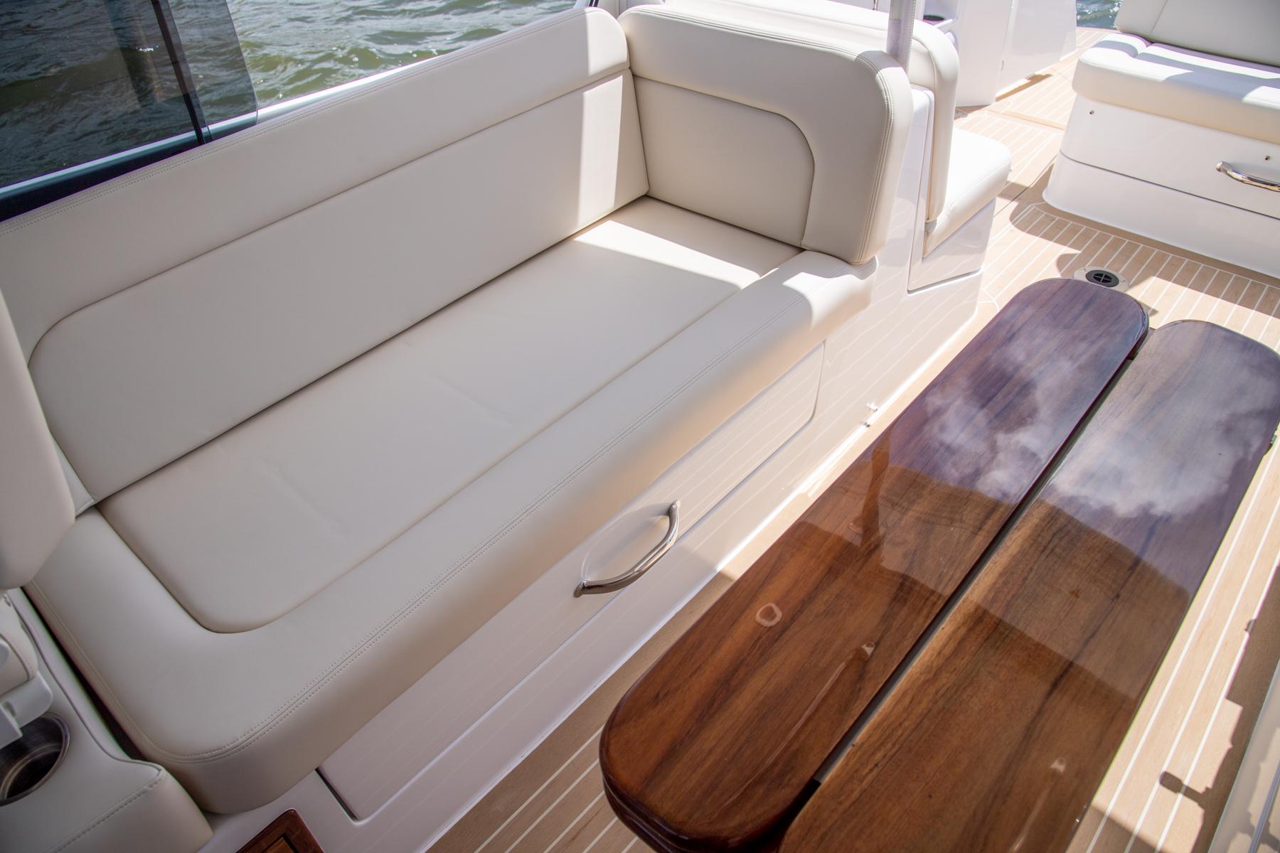 2023 MJM 35 boat interior with beige seating and wooden table.