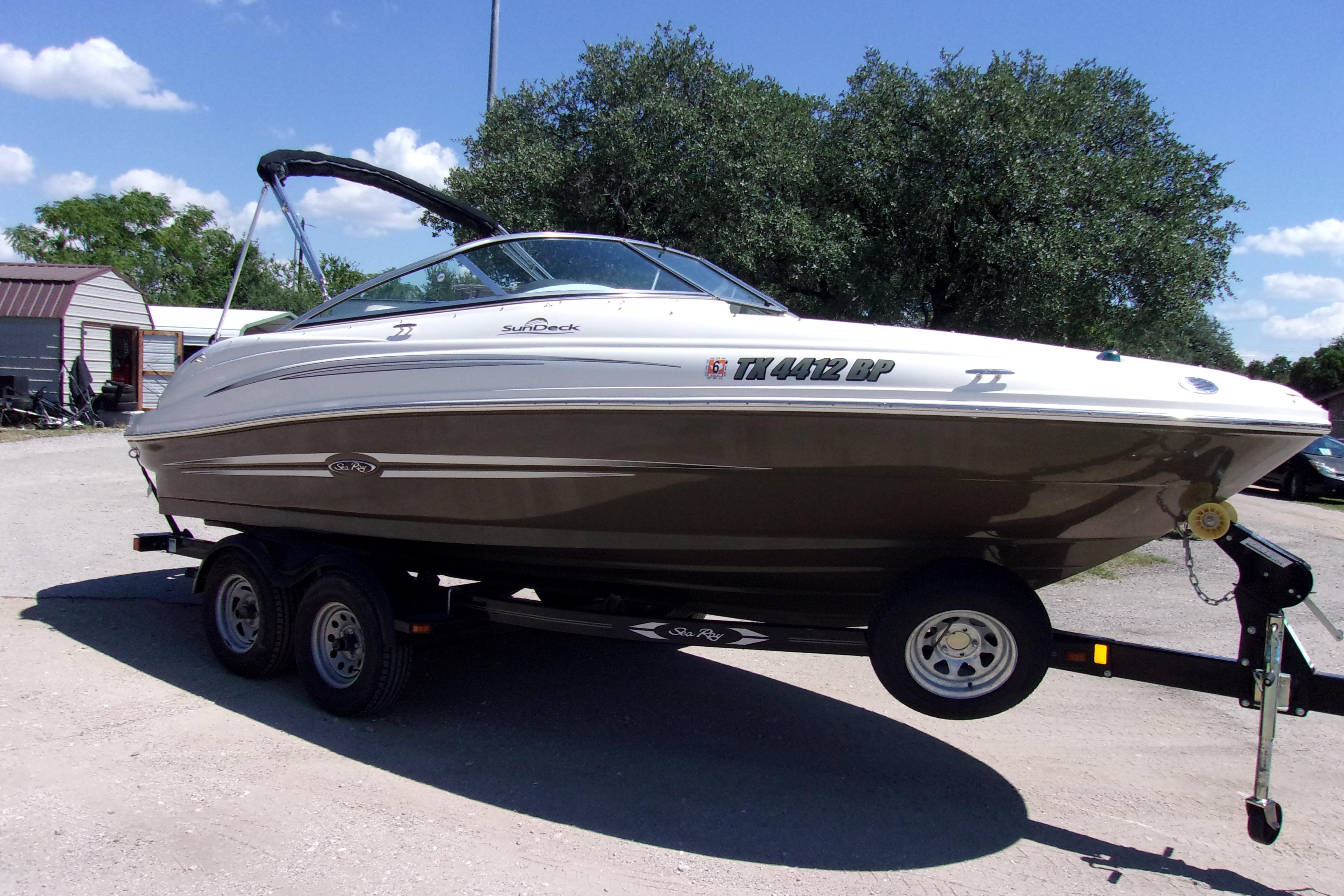 2012 Sea Ray 200 Sundeck boat on trailer, parked outdoors under clear sky.