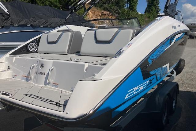 2021 Yamaha Boats 252XE, sleek design, blue accents, spacious seating, rear view.