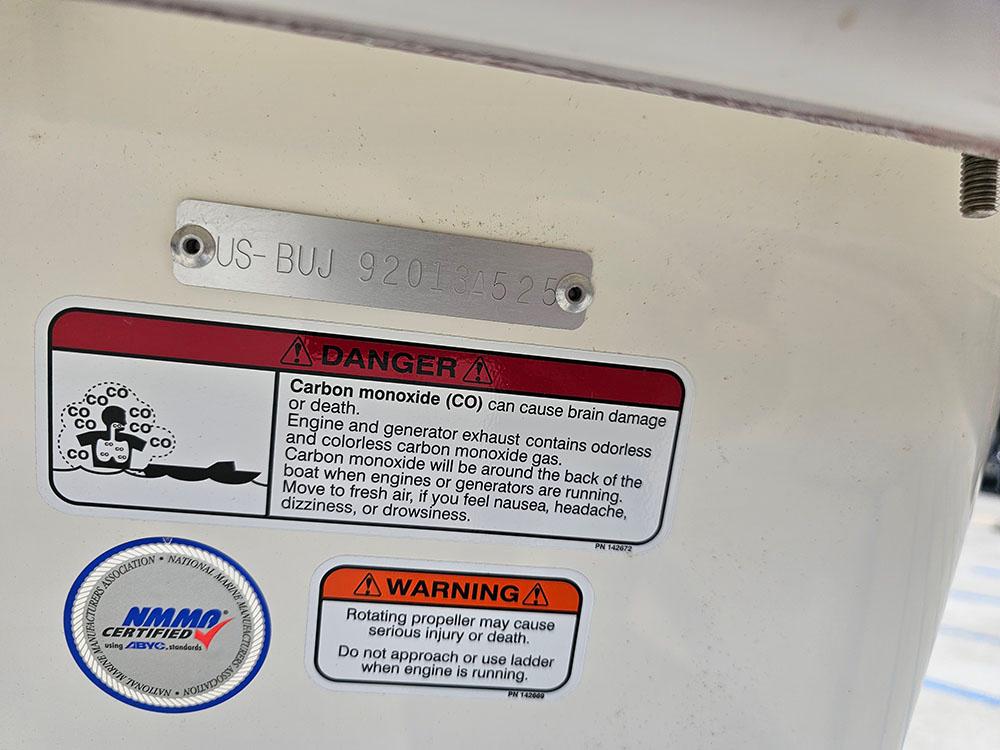 2025 Mako Pro Skiff 15 CC warning labels on carbon monoxide and propeller safety.