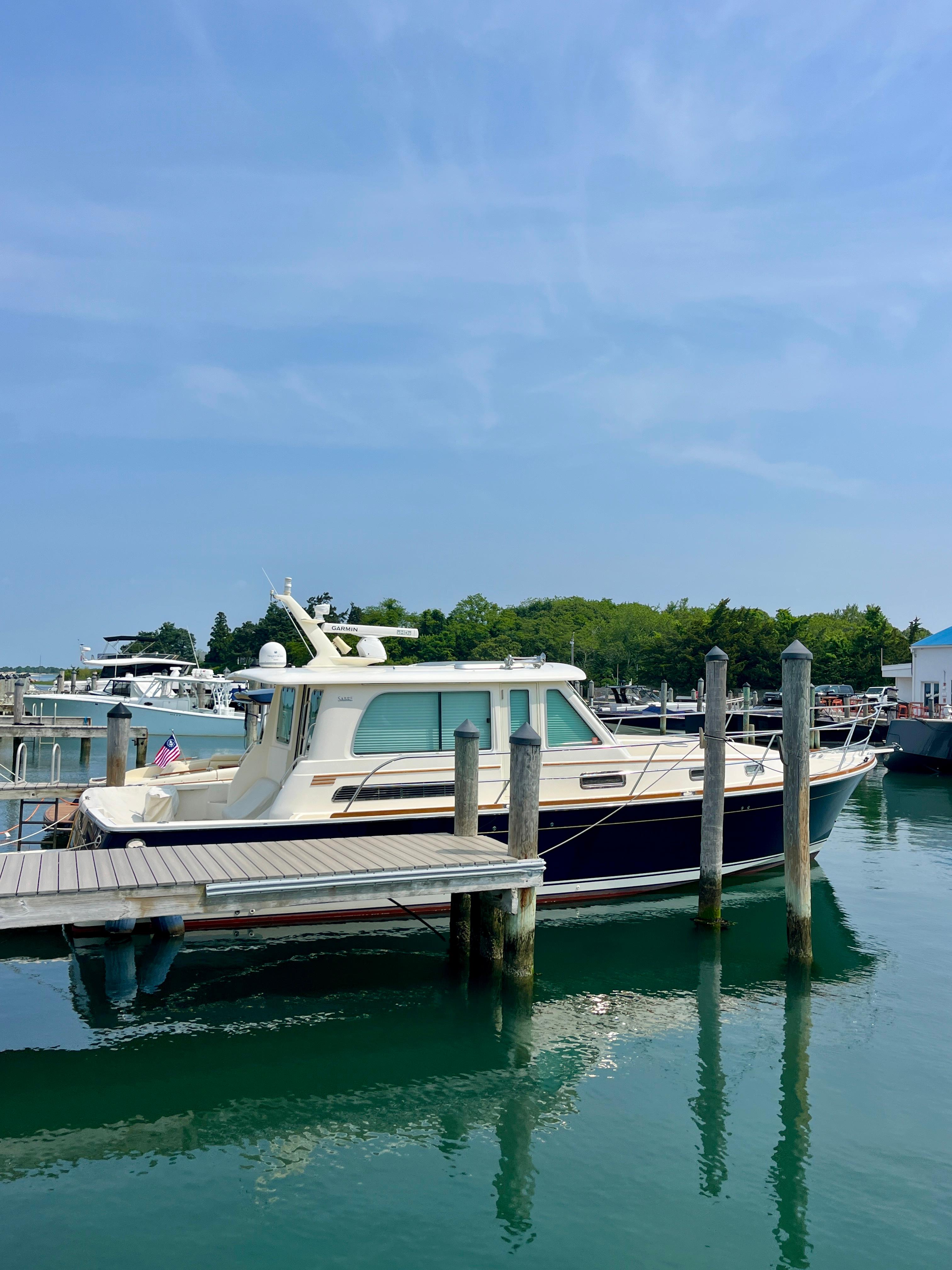 2010 Sabre 40 Sedan docked at a marina under clear blue skies.