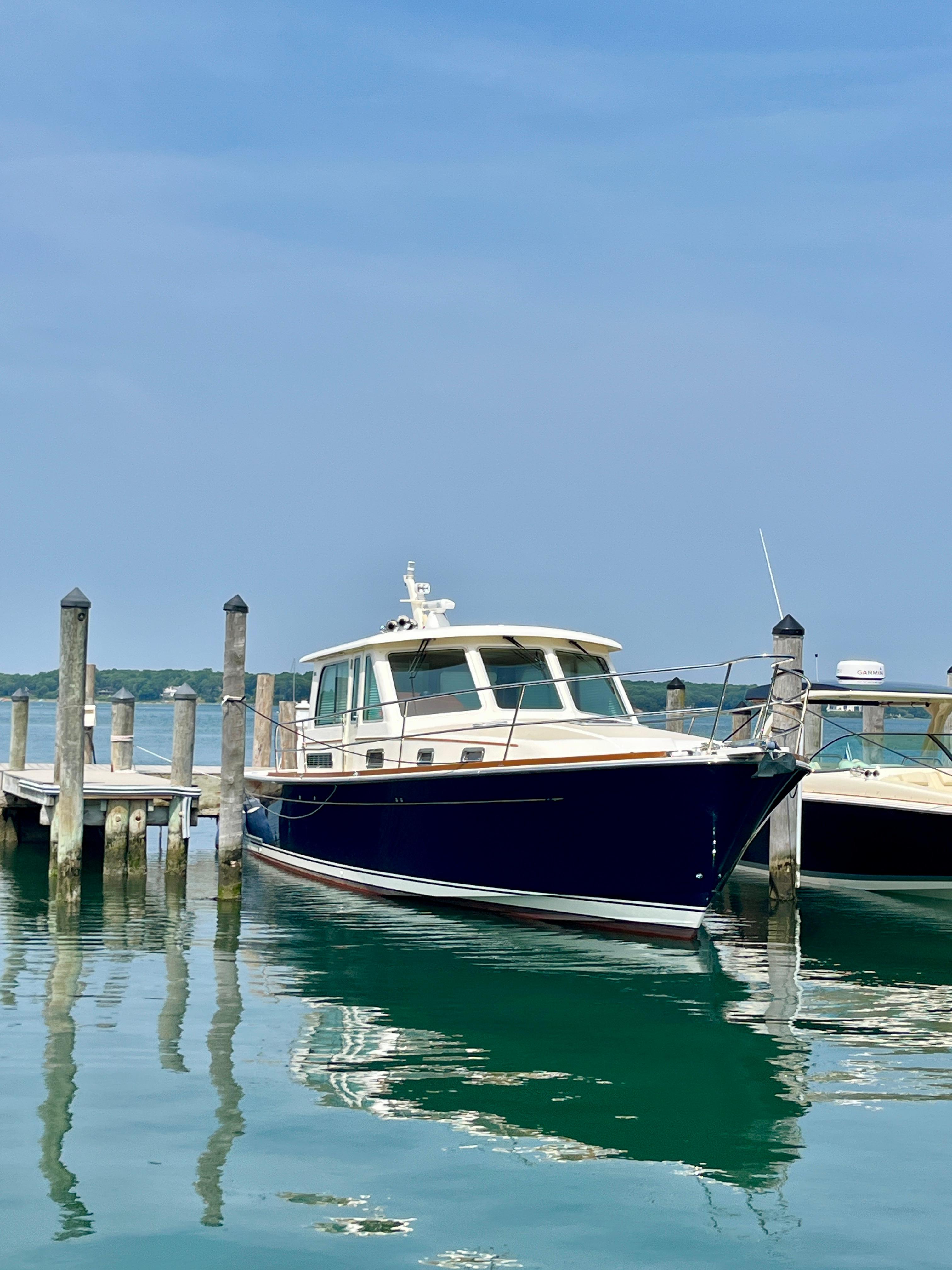 2010 Sabre 40 Sedan yacht docked at a marina on a clear day.