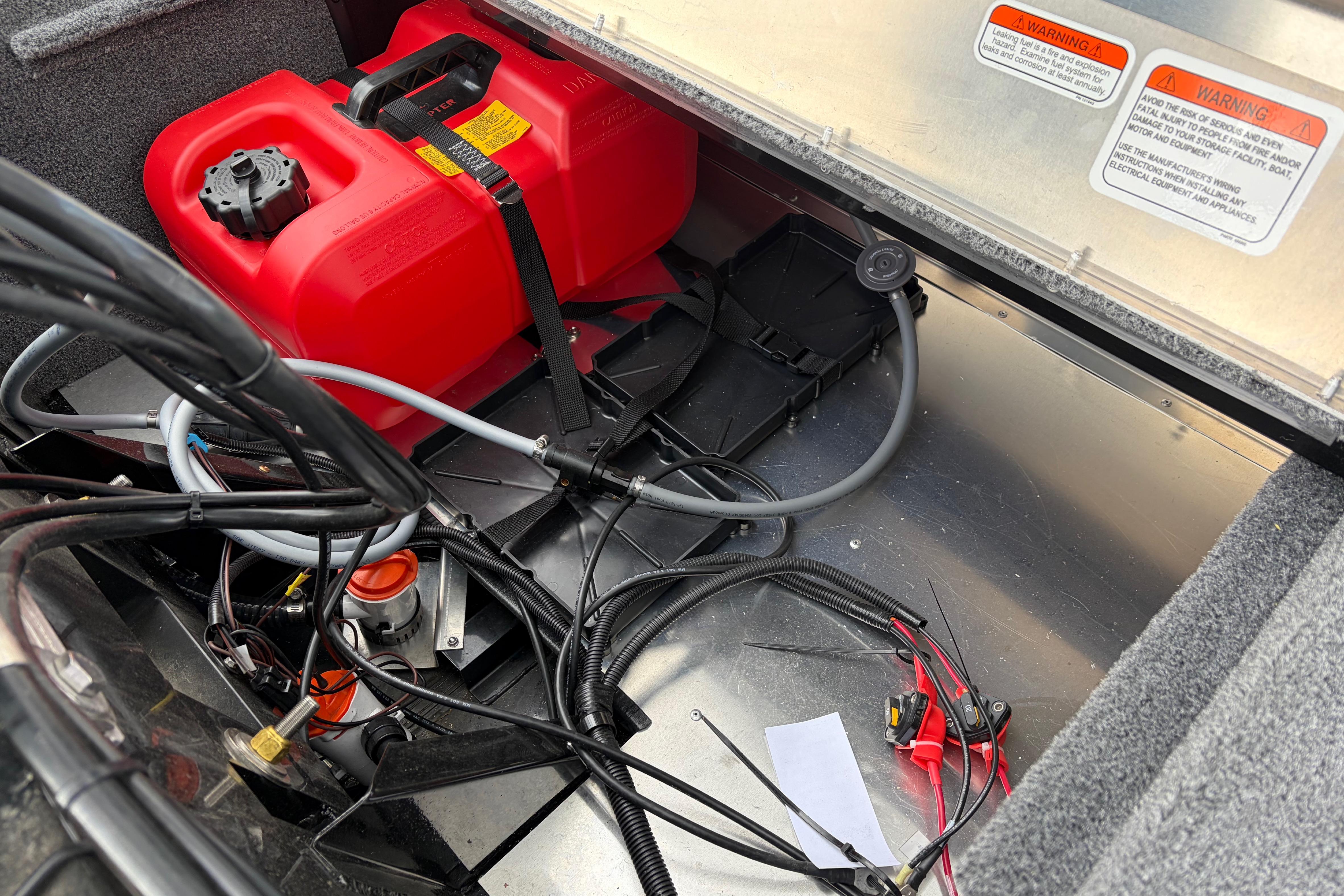 2026 Tracker Bass Tracker Classic XL boat compartment with red fuel tank and wiring.
