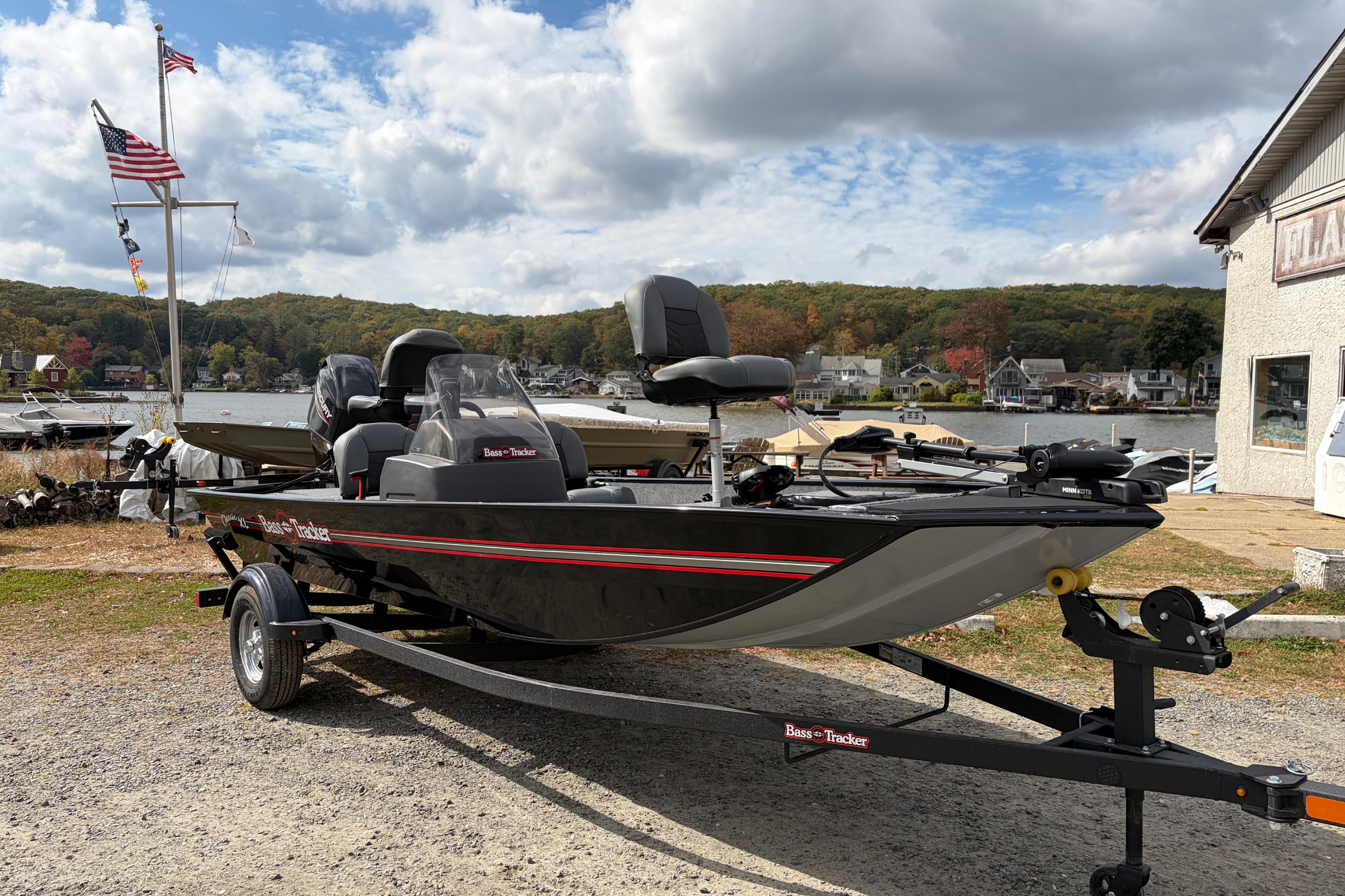 2026 Tracker Bass Tracker Classic XL boat on trailer by a scenic lakeside.