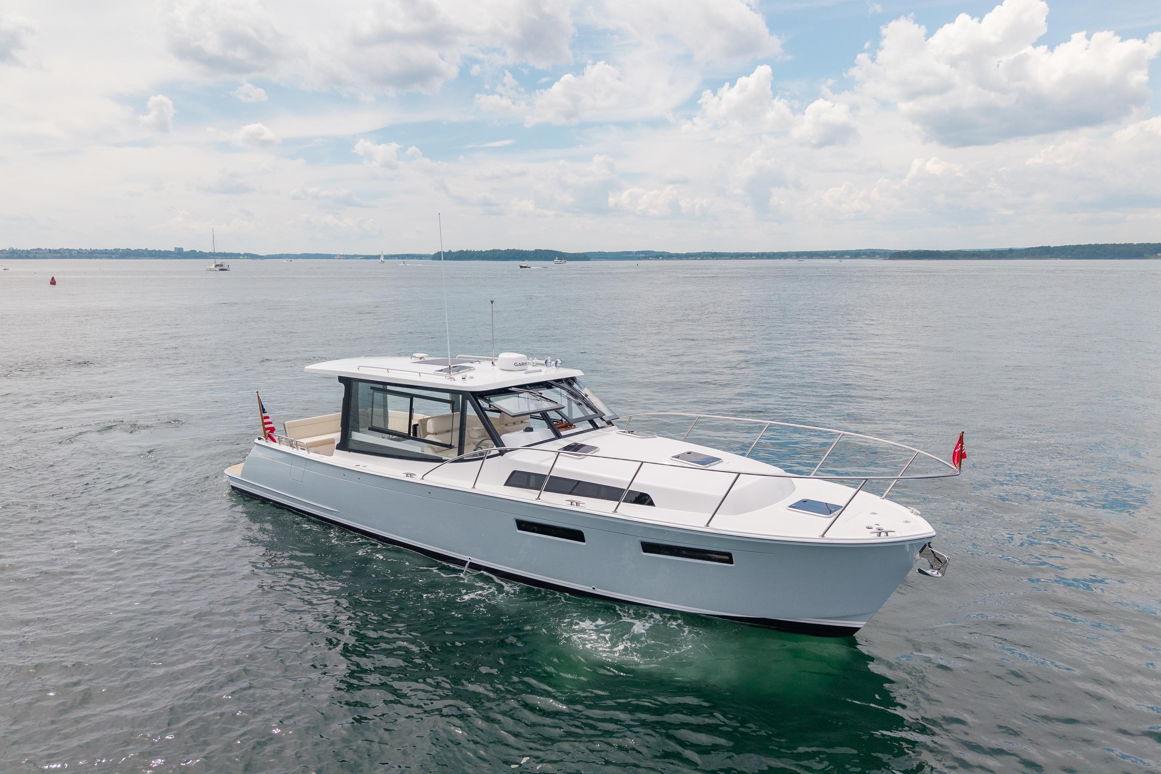 2025 MJM 42 yacht cruising on calm waters under a partly cloudy sky.