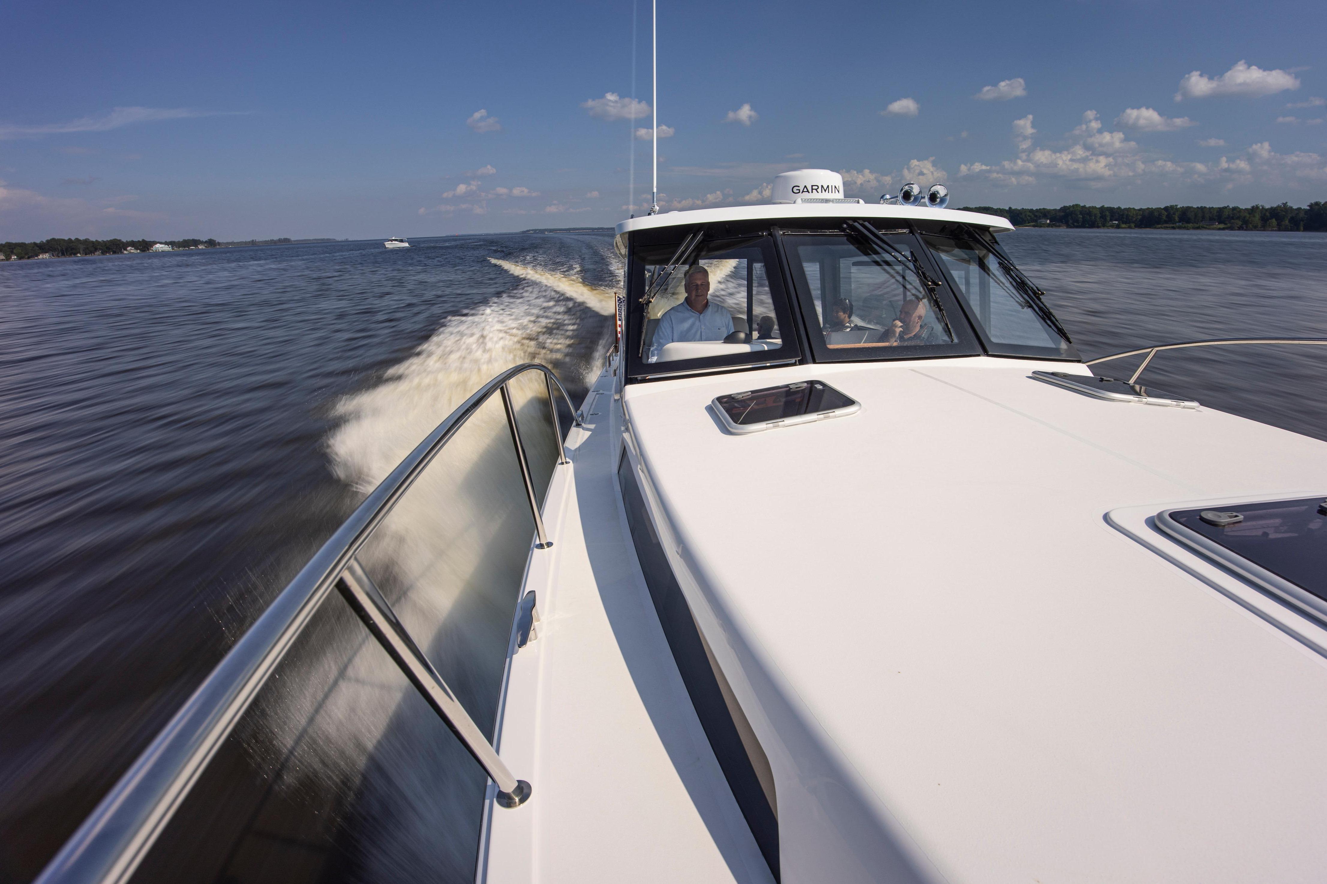2025 MJM 42 boat cruising on a sunny day with passengers onboard.