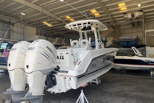 2017 Boston Whaler 280 Outrage boat with twin Mercury engines in a storage facility.