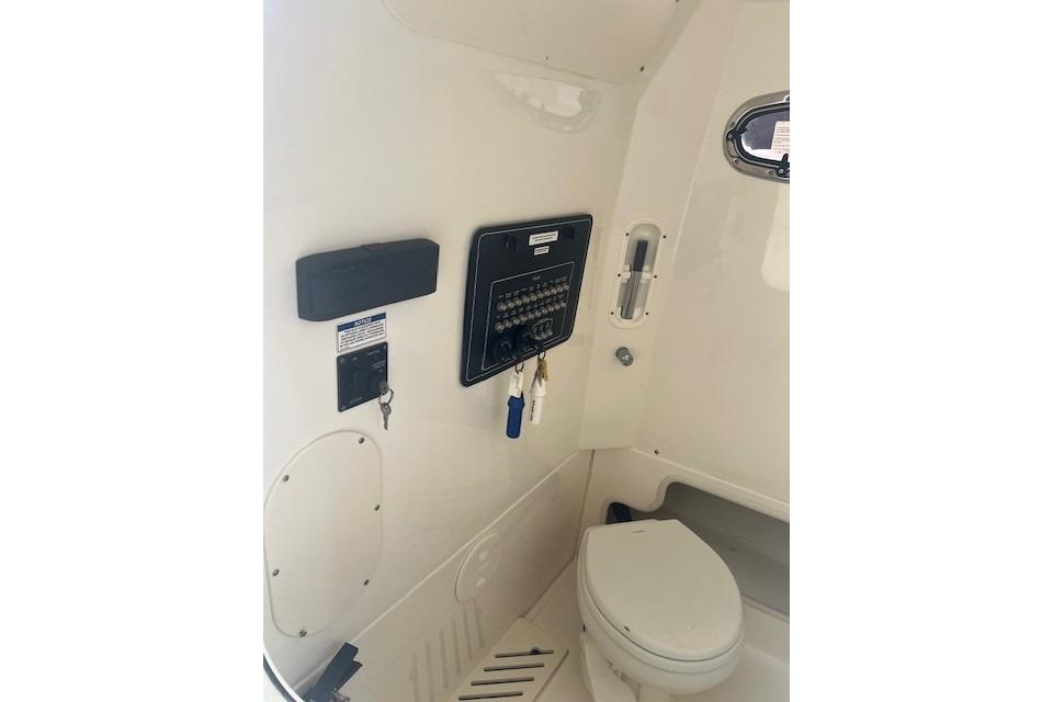 2017 Boston Whaler 280 Outrage interior with control panel and marine toilet.