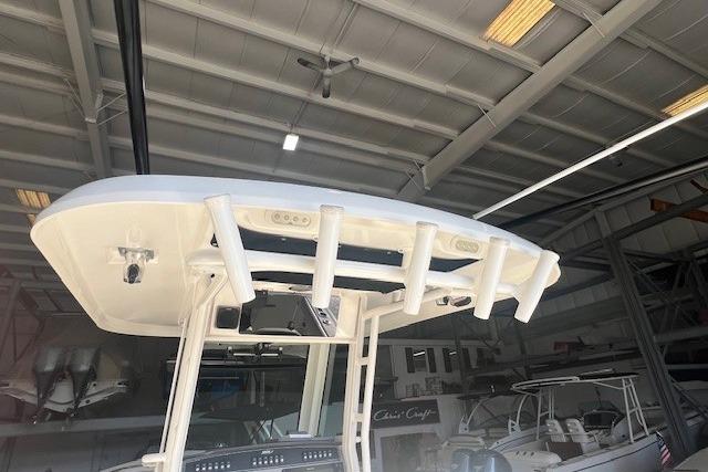 2017 Boston Whaler 280 Outrage boat in a storage facility, showcasing its T-top and rod holders.