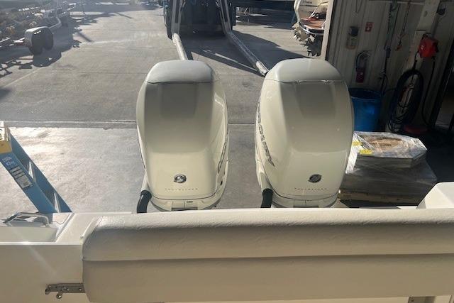 2017 Boston Whaler 280 Outrage with dual outboard engines in a garage setting.