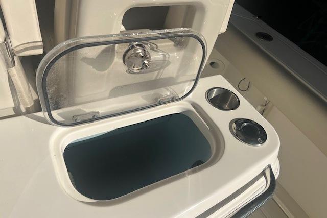 2017 Boston Whaler 280 Outrage boat interior with open storage compartment and cup holders.
